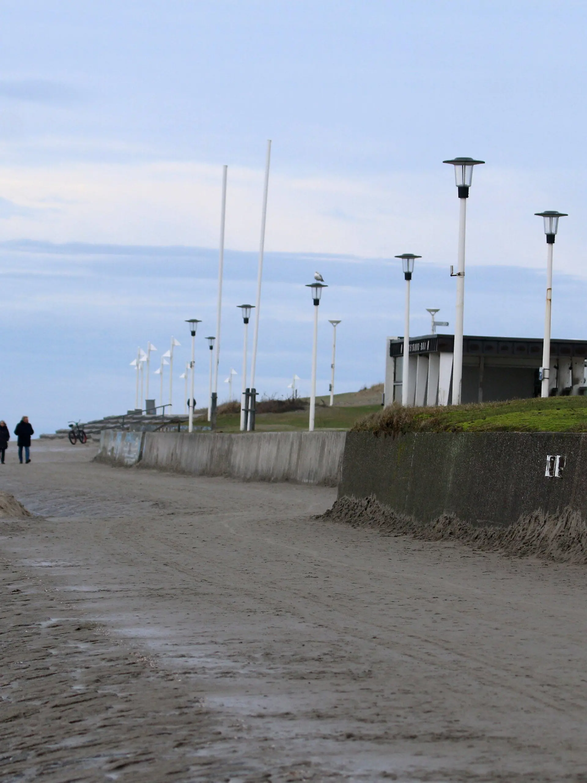 01.01.2021, Niedersachsen, Norderney: Spaziergänger sind am Weststrand der Nordsee-Insel unterwegs. Das neue Jahre startete mit Temperaturen um fünf Grad grau und windig. Foto: Volker Bartels/dpa +++ dpa-Bildfunk +++
