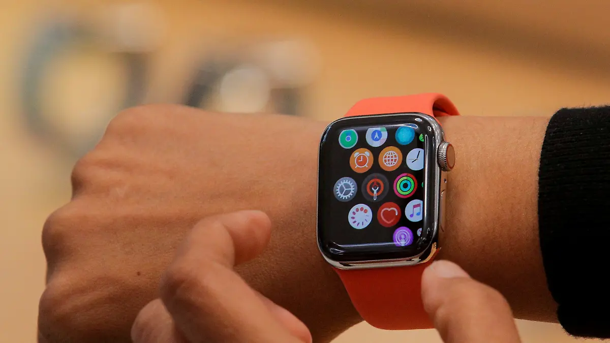 FILE PHOTO: An Apple Store employee shows the new Series 5 Apple Watch during the preview of the redesigned and reimagined Apple Fifth Avenue store in New York, U.S., September 19, 2019. REUTERS/Brendan McDermid/File Photo