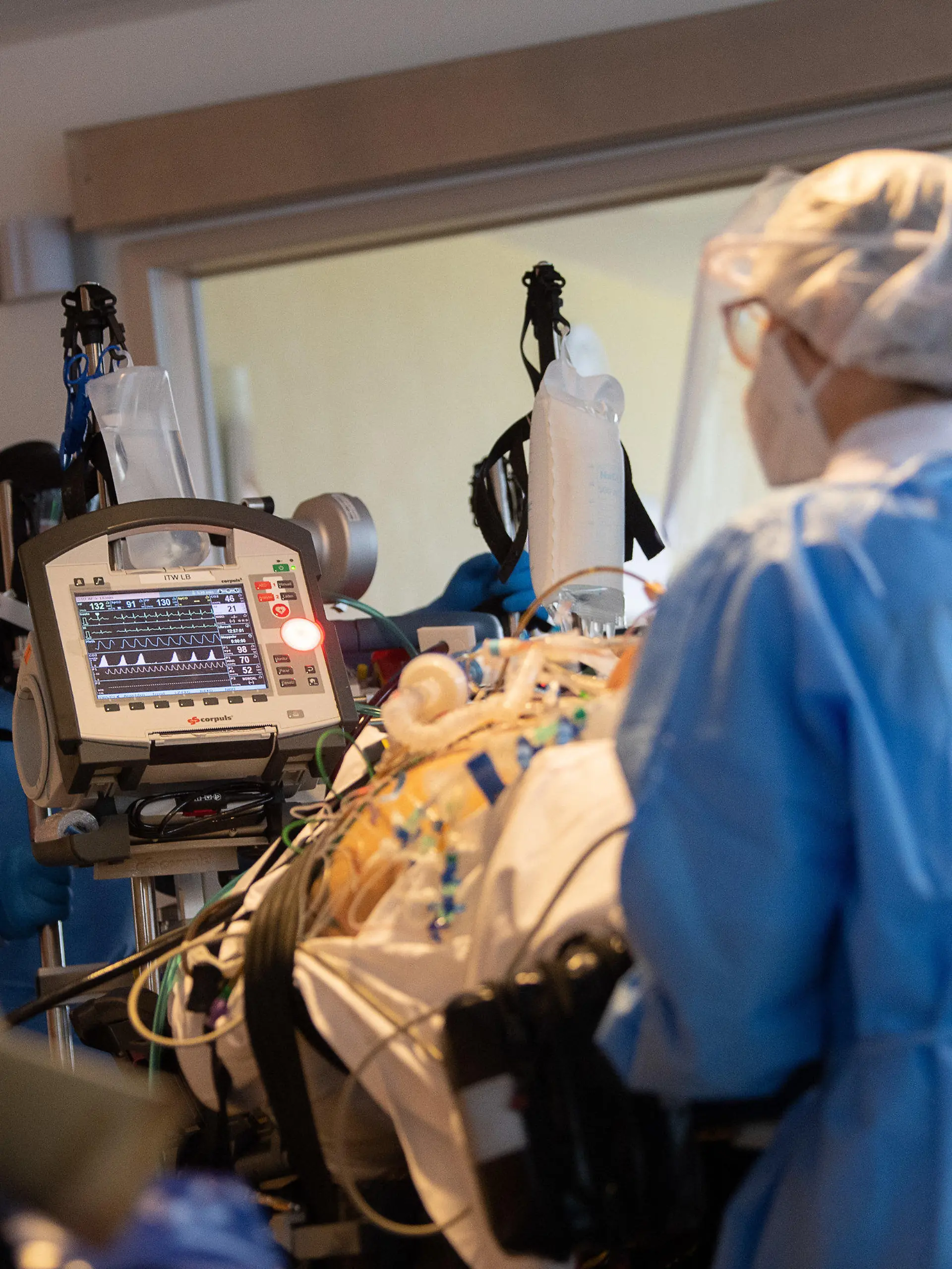 08.01.2021, Baden-Württemberg, Ludwigsburg: Das Team eines Intensivtransportwagens fährt auf einer Intensivstation des RKH Klinikum Ludwigsburg einen Covid-19-Patienten, der aus einem anderen Krankenhaus verlegt wurde, auf einer Intensivtrage. In Baden-Württemberg wird die Belegung der Intensivstationen mit einem Clusterkonzept gesteuert. Zwischen den Kliniken der sechs Versorgungsgebiete können Intensivpatienten verlegt werden, um eine bessere Verteilung zwischen den Krankenhäusern zu erreichen. Foto: Sebastian Gollnow/dpa +++ dpa-Bildfunk +++