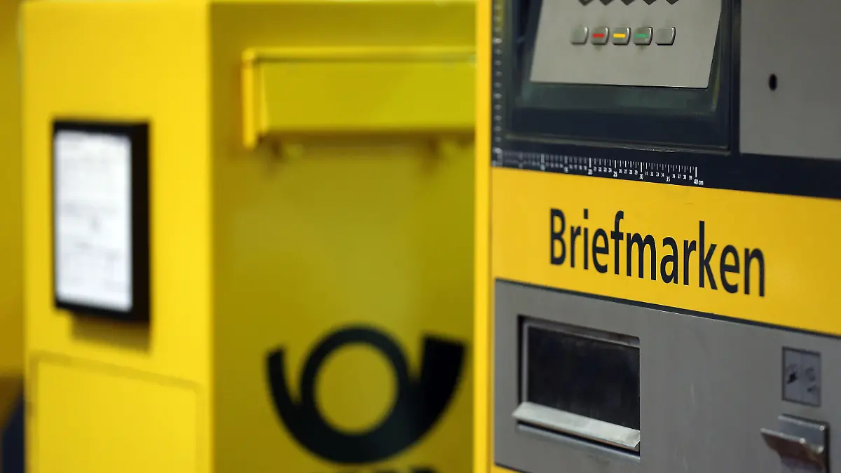 ARCHIV - 02.12.2013, Nordrhein-Westfalen, Köln: Ein Briefkasten steht neben einem Automaten für Briefmarken.    (zu dpa "Bericht: Briefporto soll später und stärker steigen") Foto: Oliver Berg/dpa +++ dpa-Bildfunk +++
