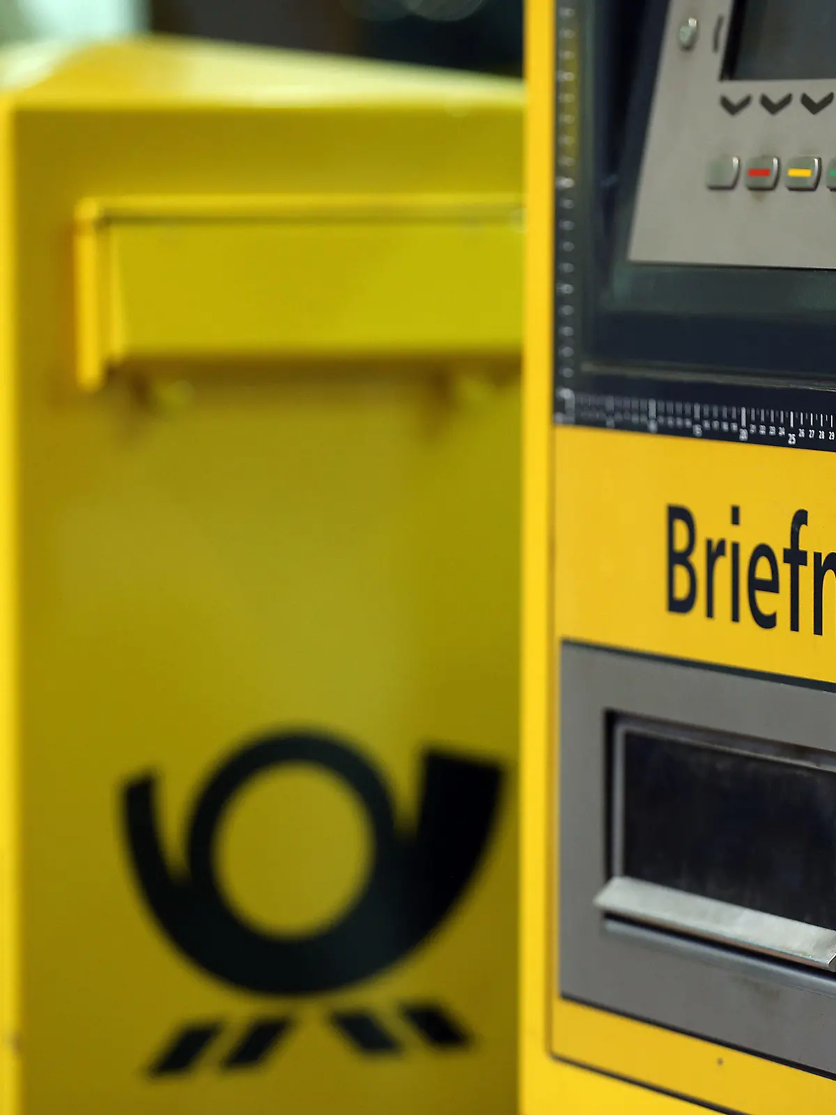 ARCHIV - 02.12.2013, Nordrhein-Westfalen, Köln: Ein Briefkasten steht neben einem Automaten für Briefmarken.    (zu dpa "Bericht: Briefporto soll später und stärker steigen") Foto: Oliver Berg/dpa +++ dpa-Bildfunk +++