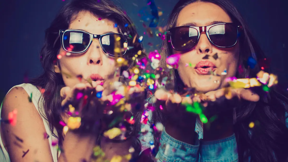 Girls blwoing confetti