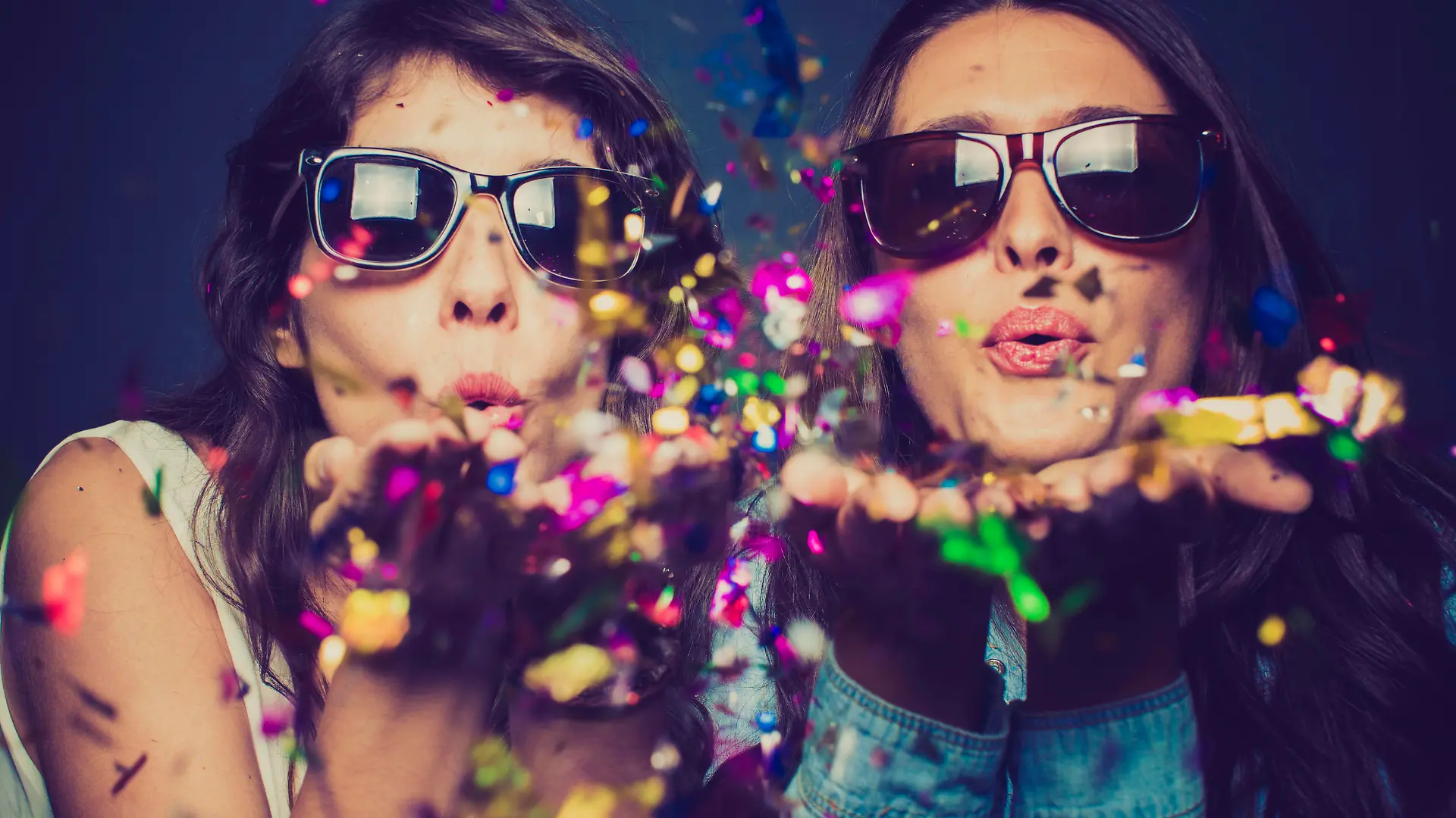 Girls blwoing confetti