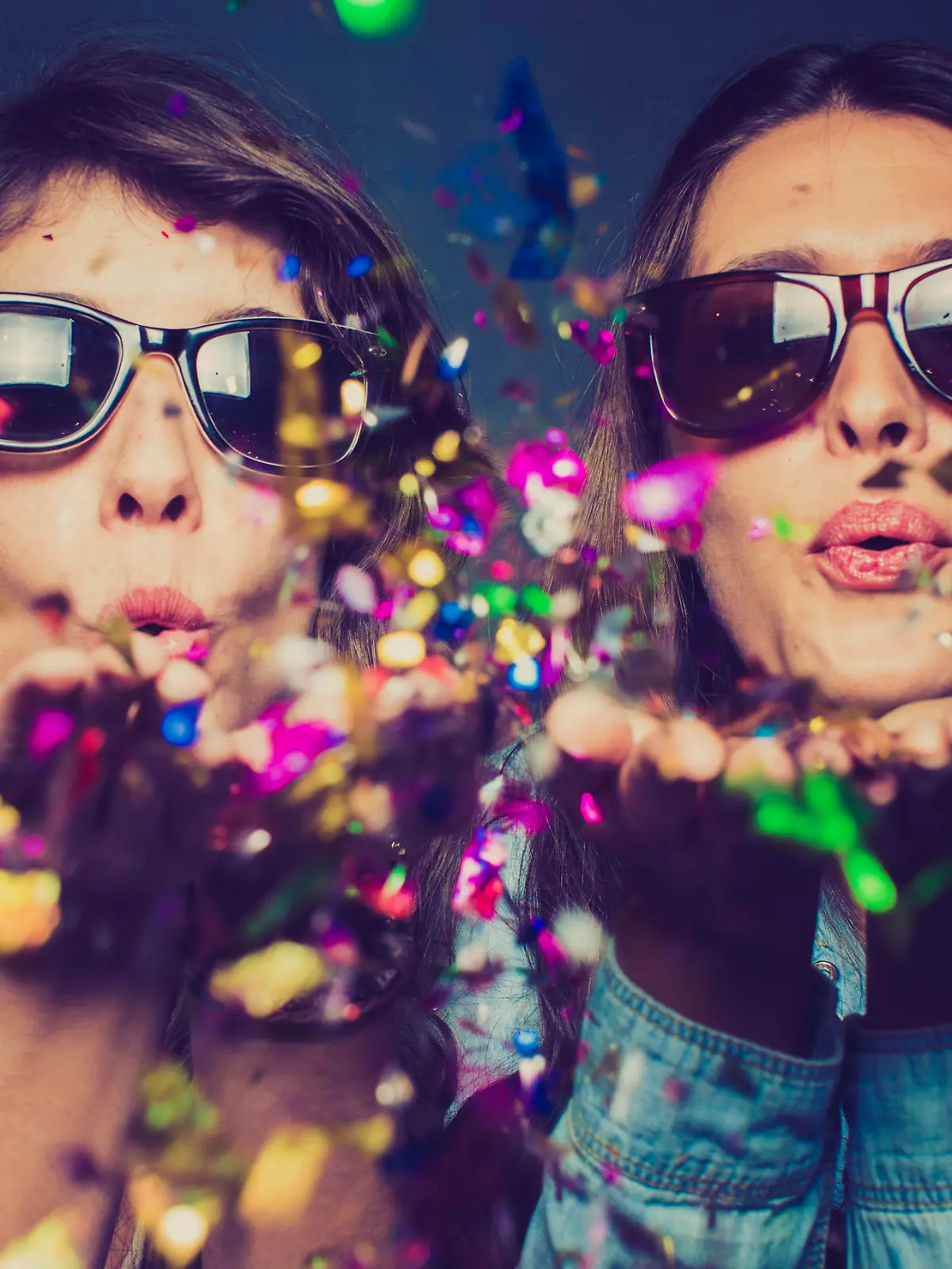 Girls blwoing confetti