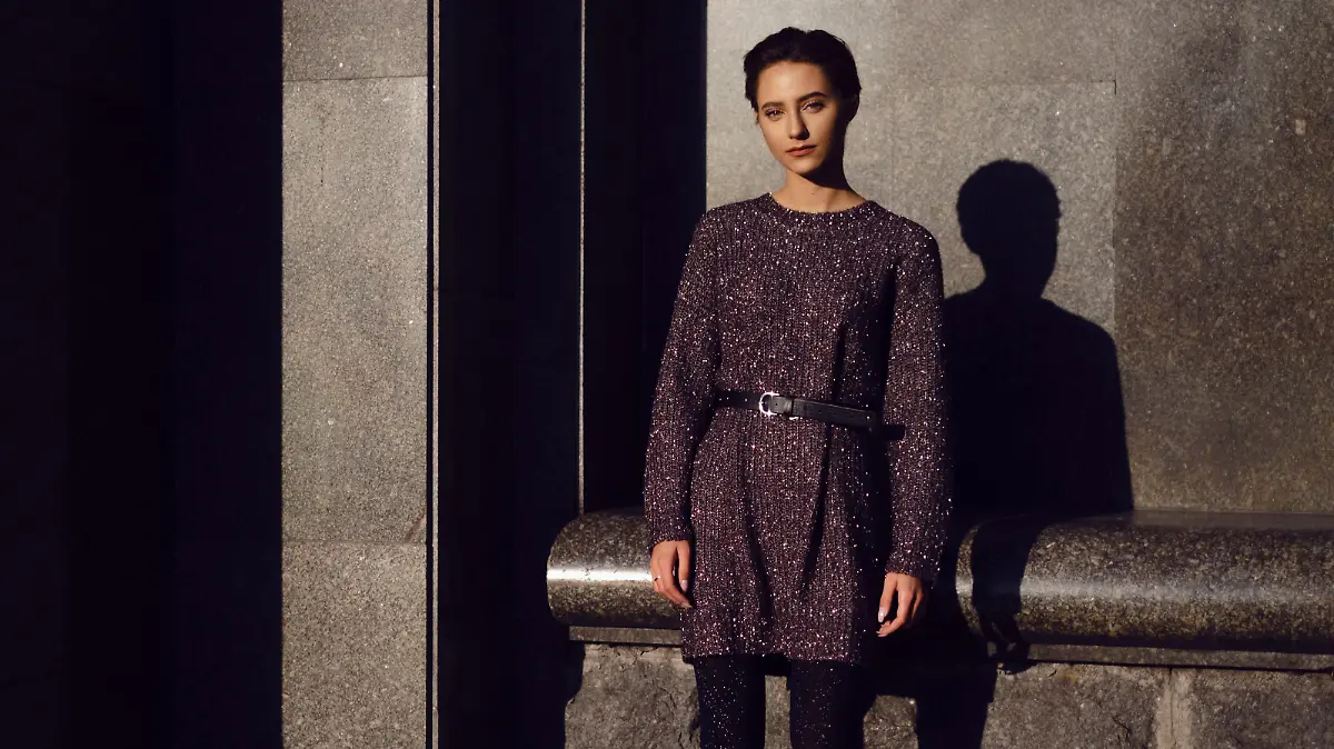 Frau trägt Strickkleid mit Gürtel.