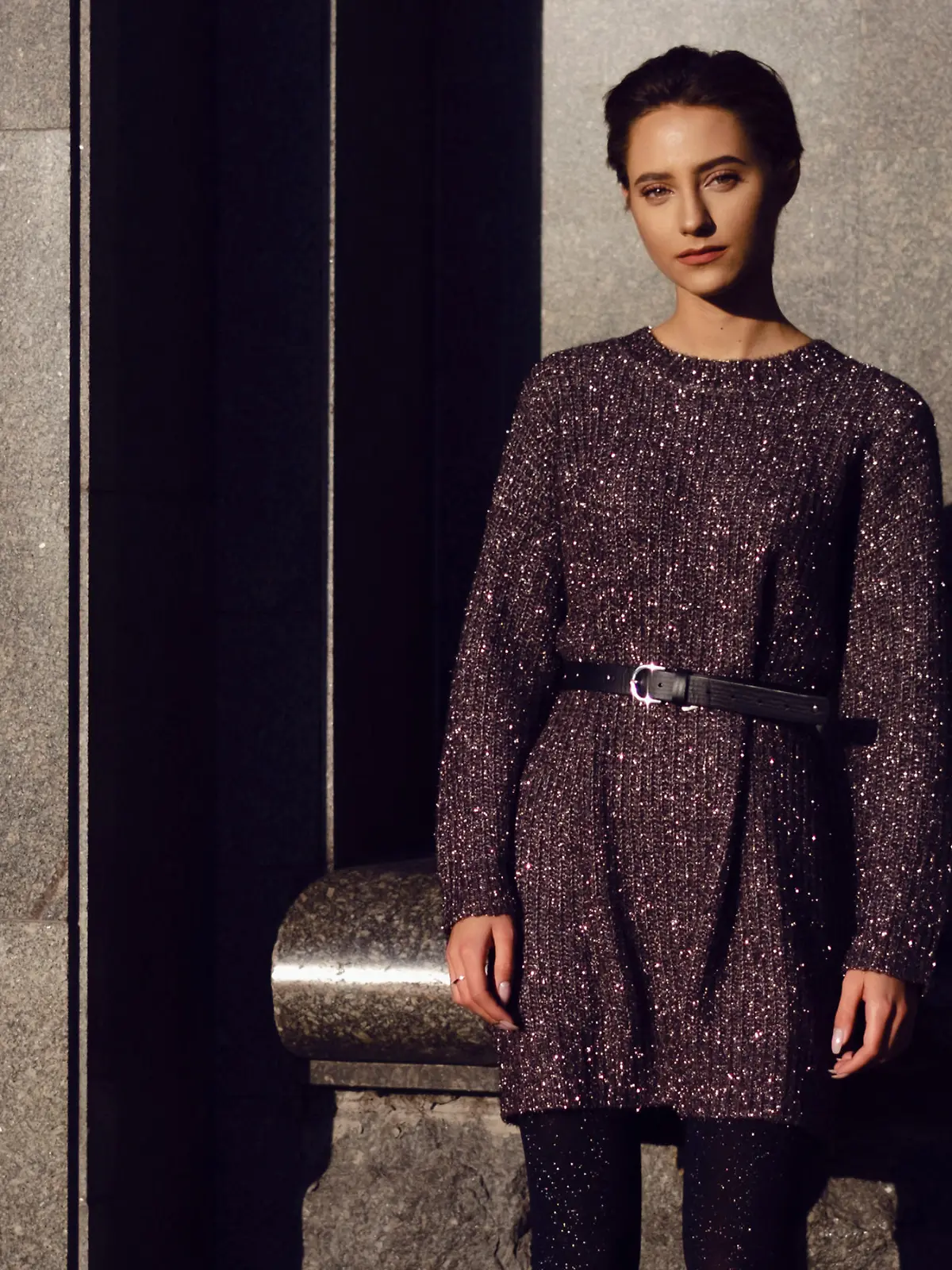 Frau trägt Strickkleid mit Gürtel.