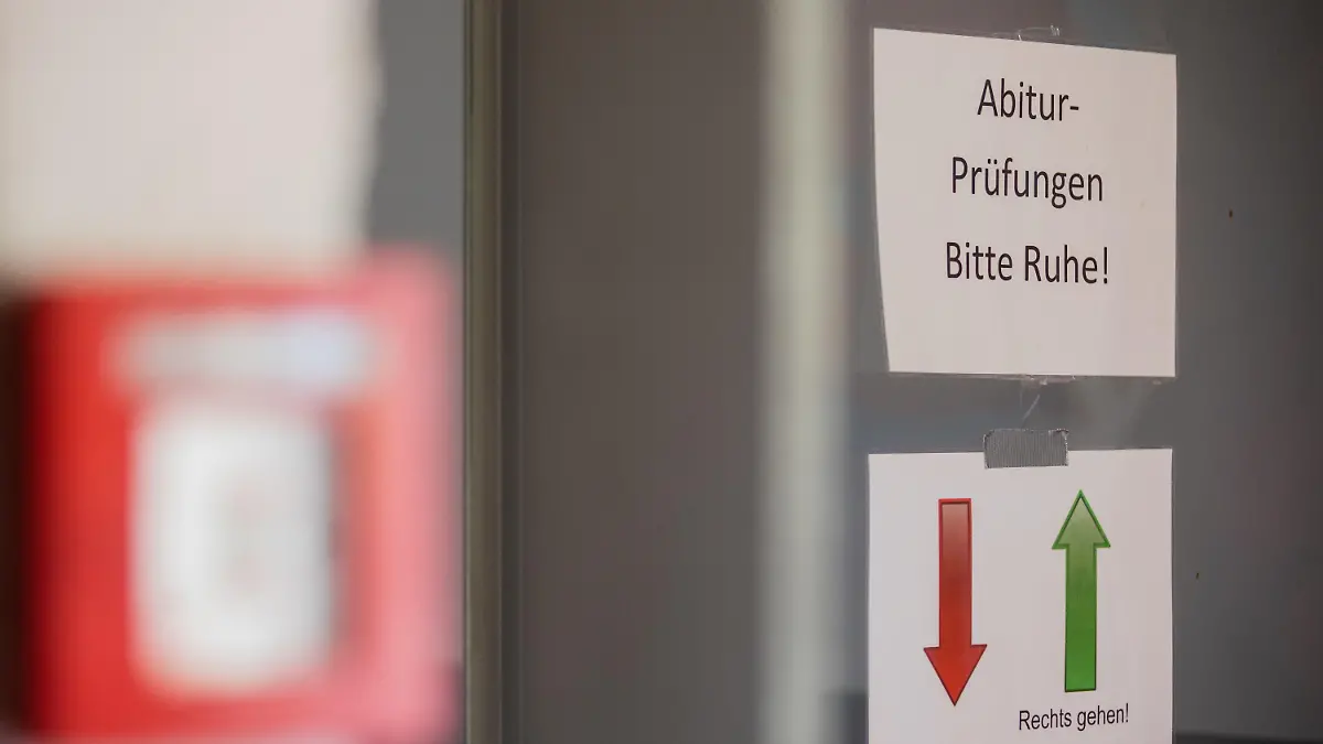 ARCHIV - 08.05.2020, Nordrhein-Westfalen, Pulheim: Ein Hinweisschild mit der Aufschrift «Abitur-Prüfungen - Bitte Ruhe!» hängt vor einem Flur im Gymnasium. (zu dpa «Holter kann sich leichtere Schulprüfungen wegen Corona vorstellen») Foto: Rolf Vennenbernd/dpa +++ dpa-Bildfunk +++