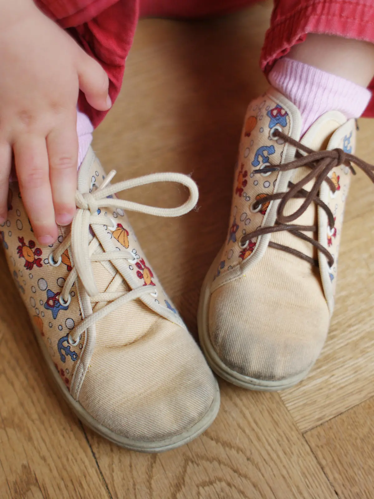 Symbolbild zum Thema Kinderarmut - Ein Kind (ein kleines Mädchen) trägt ein Paar stark abgetragene Schuhe aus Stoff mit verschiedenen Schnürsenkeln in Frankfurt am Main am 22.04.2009 (gestelltes Foto zur Illustration). Immer mehr Kinder in Deutschland leben in Armut und von Hartz 4 (Hartz IV). Ihre Eltern können oft selbst die einfachen Dinge des täglichen Bedarfs nicht mehr bezahlen. Foto: Wolfram Steinberg +++(c) dpa - Report+++
