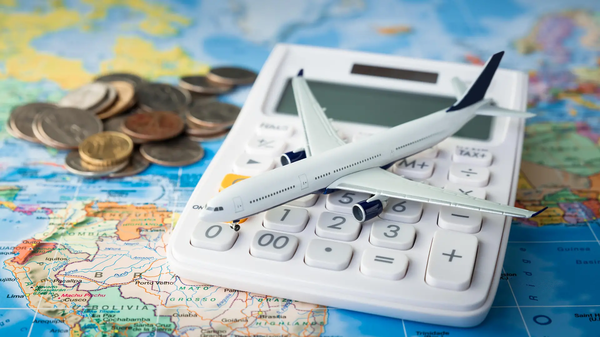 Spielzeugflugzeit und Taschenrechner auf Landkarte