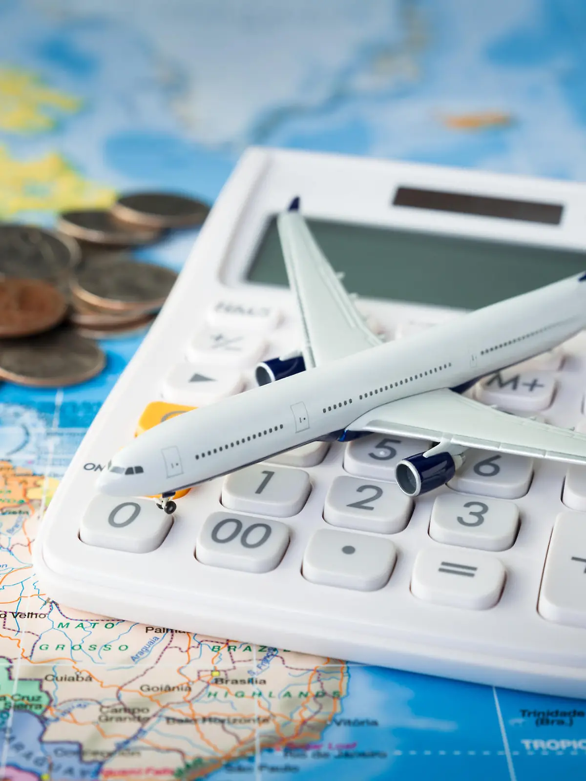 Spielzeugflugzeit und Taschenrechner auf Landkarte