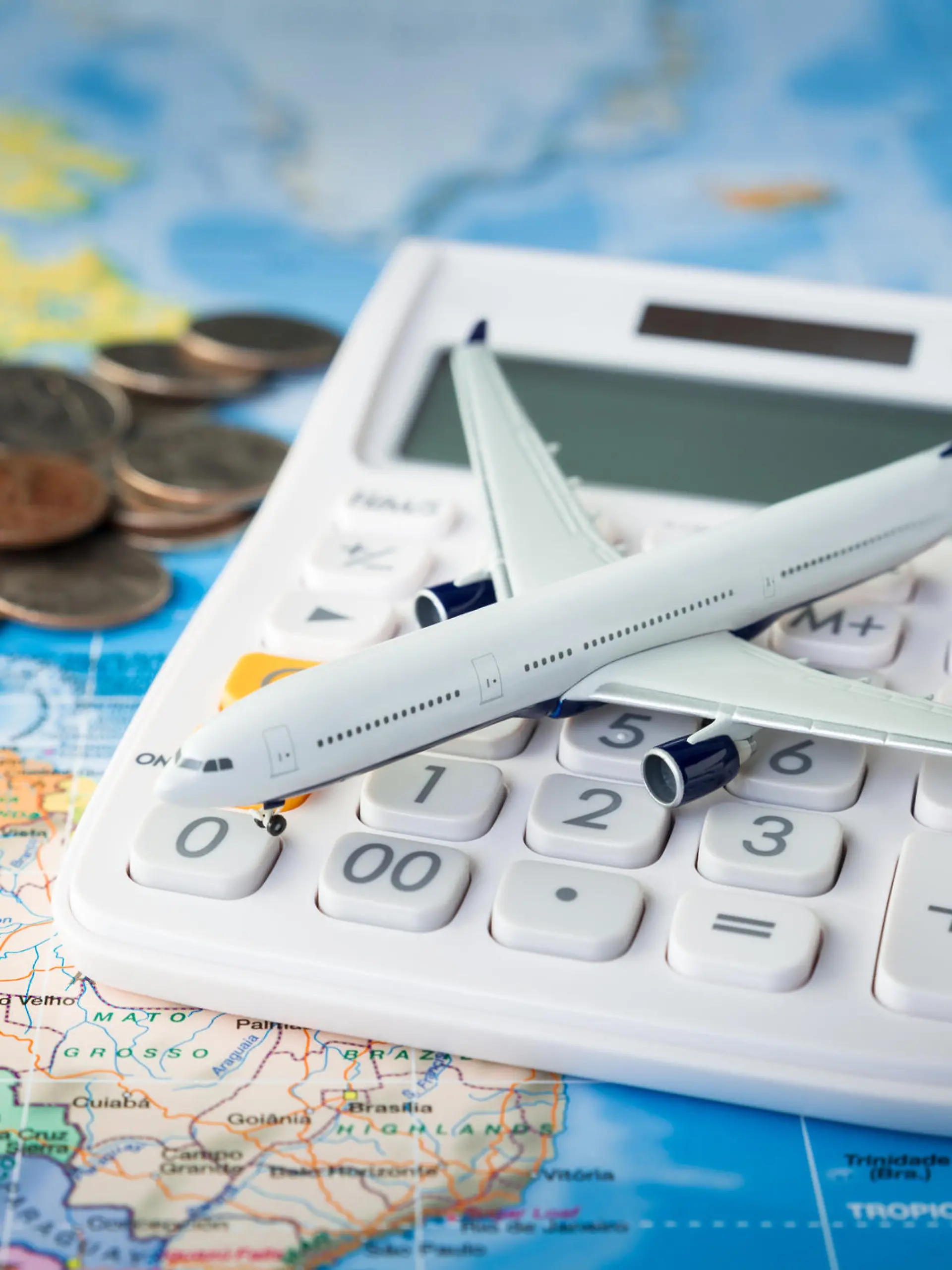 Spielzeugflugzeit und Taschenrechner auf Landkarte