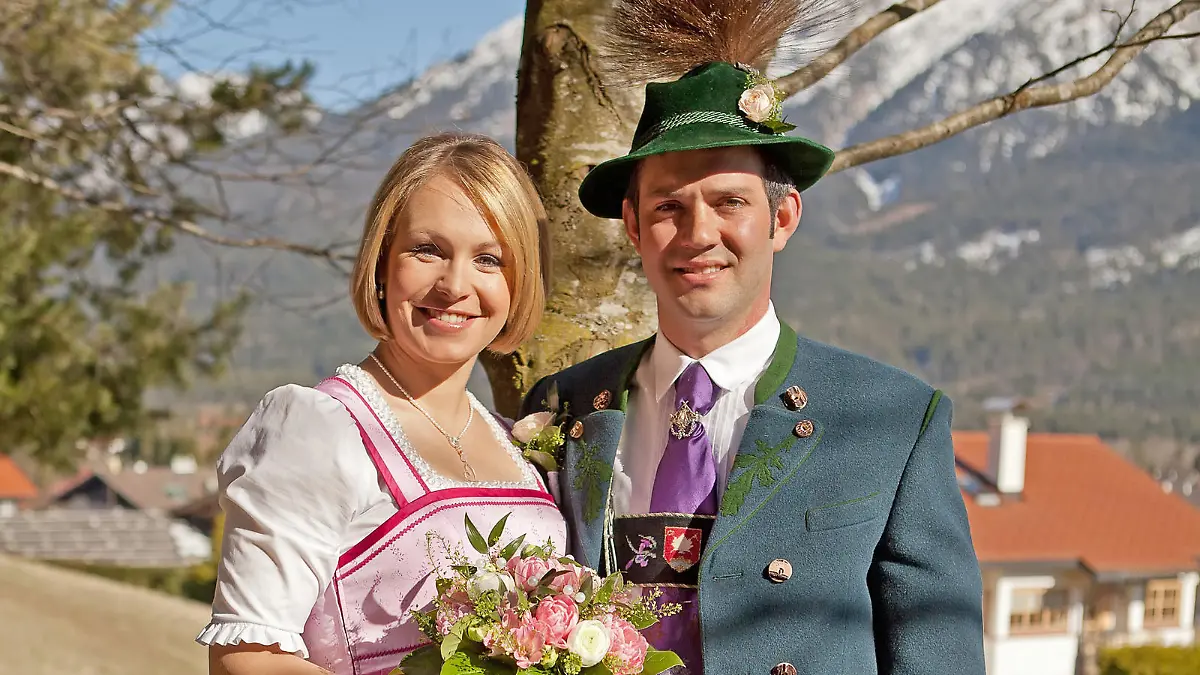HANDOUT - In bayerischer Tracht stehen die Biathletin Magdalena Neuner und ihr Ehemann Josef Holzer auf ihrem Hochzeitsfoto am 29.03.2014 an einem Baum in Walgau (Bayern). Kurz vor der Geburt ihres ersten Kindes gab die Rekord-Weltmeisterin ihrem langjährigen Freund Josef Holzer das Ja-Wort.   Foto: Thomas Wimmer/dpa   (zu dpa "Lena im Glück: Neuner heiratet und freut sich auf ihr Baby" vom 30.03.2014 - ACHTUNG: Verwendung nur zu redaktionellen Zwecken und bei vollständiger Quellenangabe "Thomas Wimmer/dpa") +++(c) dpa - Bildfunk+++