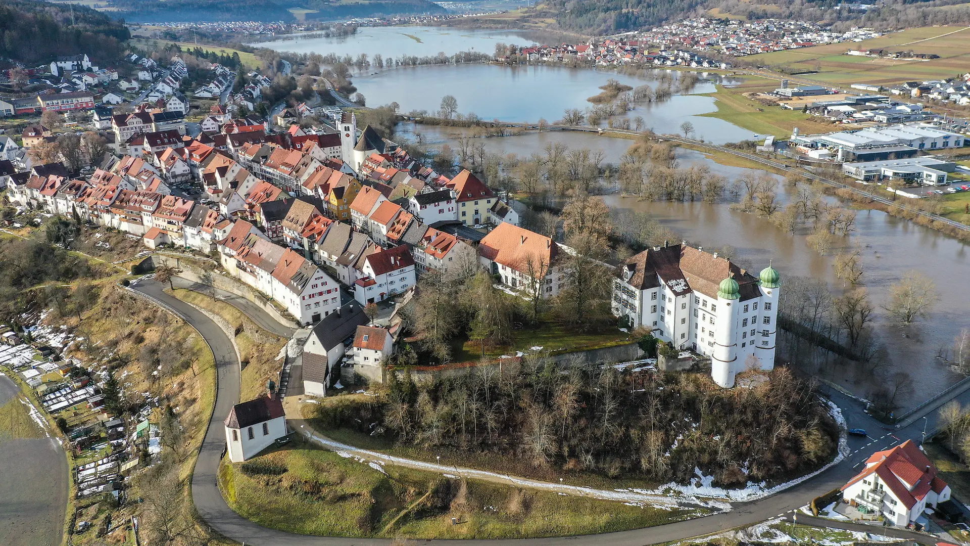 04.02.2021, Baden-Württemberg, Mühlheim an der Donau: Die Stadt Mühlheim liegt an der Donau, die durch das Hochwasser derzeit über die Ufer getreten ist. Die Stadt Mühlheim an der Donau hat eine besonders hohe Inzidenz verursacht durch eine Wandergruppe. Aufnahme mit Drohne Foto: Felix Kästle/dpa +++ dpa-Bildfunk +++