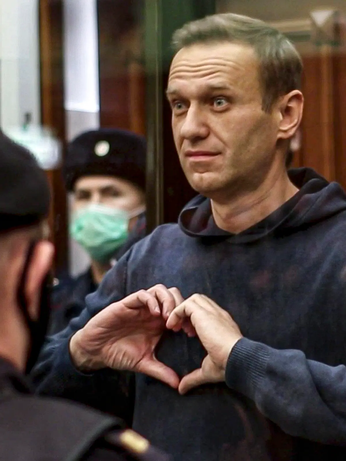 HANDOUT - 02.02.2021, Russland, Moskau: Dieses vom Moskauer Gericht zur Verfügung gestellte Foto zeigt den russischen Oppositionsführer Alexej Nawalny, der im Gerichtssaal mit seinen Händen ein Herz formt. Der Kremlgegner Alexej Nawalny wird wie erwartet durch ein Moskauer Gerichtsurteil für Jahre politisch kalt gestellt. Foto: Uncredited/Moscow City Court/AP/dpa - ACHTUNG: Nur zur redaktionellen Verwendung im Zusammenhang mit der aktuellen Berichterstattung und nur mit vollständiger Nennung des vorstehenden Credits +++ dpa-Bildfunk +++