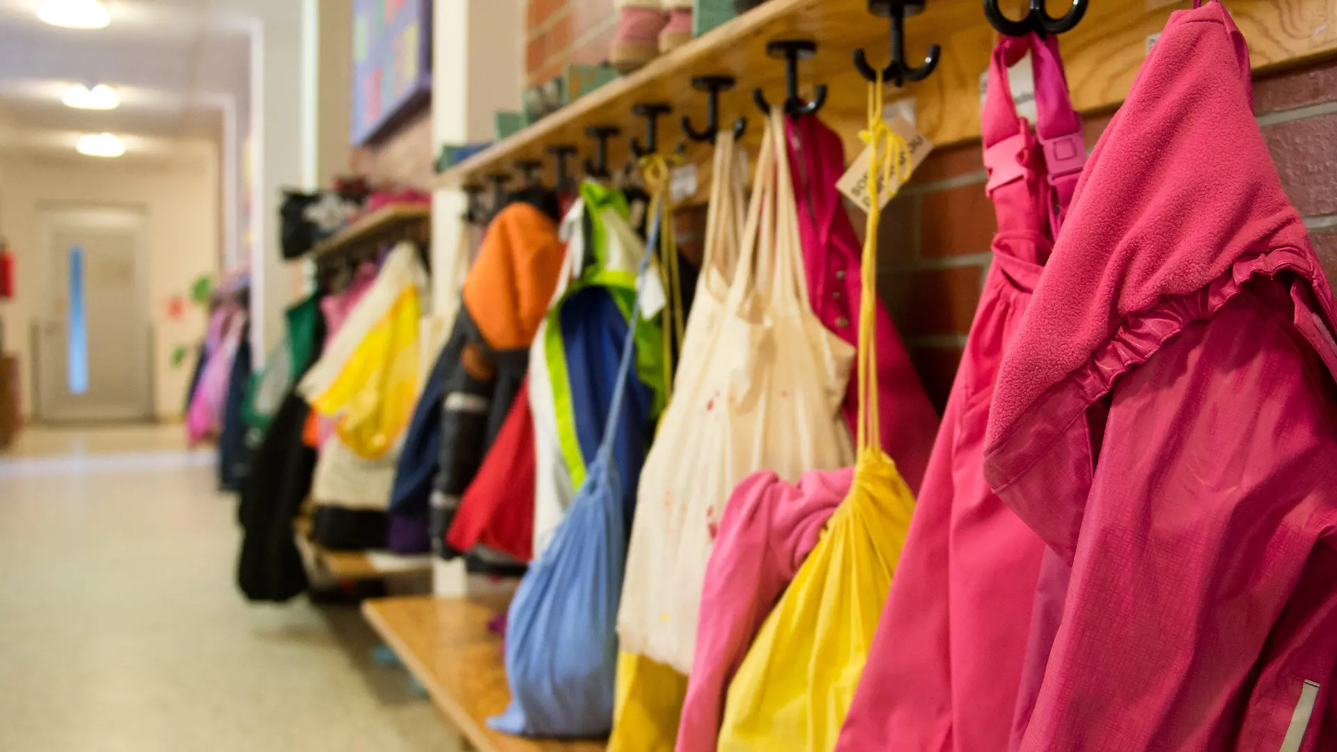 ARCHIV - 21.05.2015, Baden-Württemberg, Stuttgart: Jacken und Turnbeutel sind in einer Kindertagesstätte an einer Garderobe zu sehen. Sozialassistenten und Kinderpfleger sollen die Personalnot an Thüringer Kindergärten lindern. Bis zu zehn Prozent des Personals an einer Kita sollen künftig aus diesen beiden Berufsgruppen kommen dürfen, wie das Bildungsministerium am Mittwoch mitteilte (zu dpa «Ministerium lockert Einstellungsregeln für Personal in Kitas»). Foto: Daniel Naupold/dpa +++ dpa-Bildfunk +++