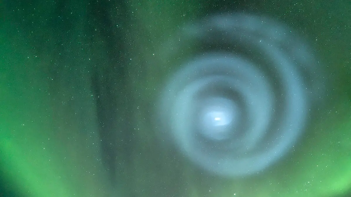 In this photo provided by Todd Salat, northern light enthusiasts got a surprise early April 15, 2023, when something odd was mixed in with the green bands of light dancing above the Donnelly Dome near Delta Junction, Alaska. A light baby blue spiral resembling a galaxy appeared amid the aurora for a few minutes. The spiral was formed when excess fuel that had been released from a SpaceX rocket that launched from California about three hours earlier turned to ice, and then the water vapor reflected the sunlight in the upper atmosphere. (Todd Salat via AP)