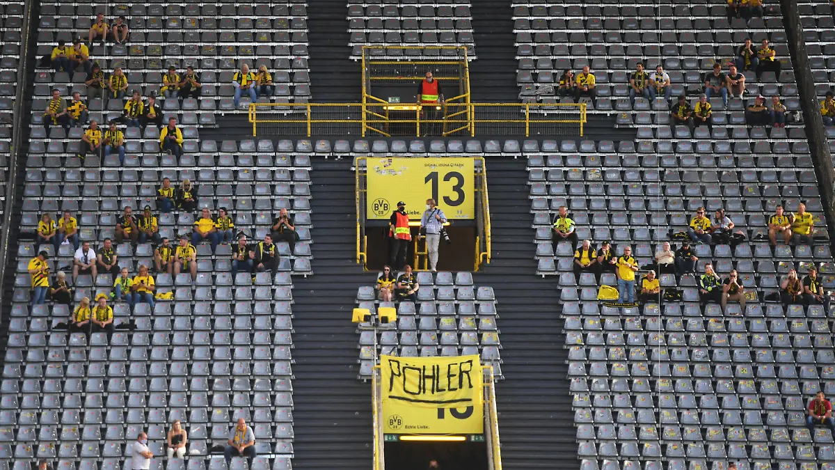 ARCHIV - 19.09.2020, Nordrhein-Westfalen, Dortmund: Fußball: Bundesliga, Borussia Dortmund - Borussia Mönchengladbach, 1. Spieltag im Signal Iduna Park. Zuschauer sitzen vor dem Spiel auf der Tribüne. WICHTIGER HINWEIS: Gemäß den Vorgaben der DFL Deutsche Fußball Liga bzw. des DFB Deutscher Fußball-Bund ist es untersagt, in dem Stadion und/oder vom Spiel angefertigte Fotoaufnahmen in Form von Sequenzbildern und/oder videoähnlichen Fotostrecken zu verwerten bzw. verwerten zu lassen. (Zu dpa "Offener BVB-Brief an die Fans: Profifußball kein Treiber der Pandemie") Foto: Bernd Thissen/dpa +++ dpa-Bildfunk +++