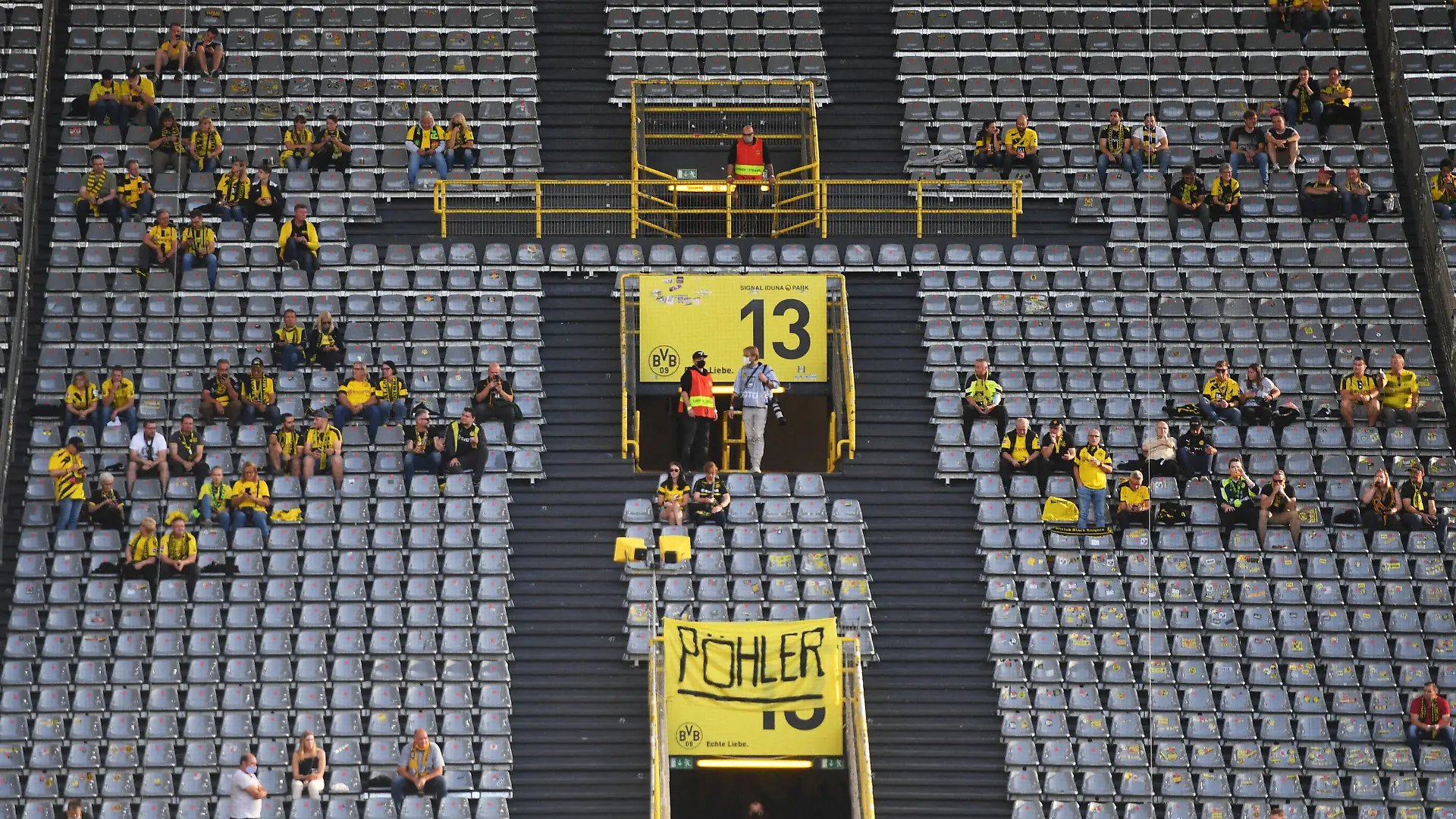 ARCHIV - 19.09.2020, Nordrhein-Westfalen, Dortmund: Fußball: Bundesliga, Borussia Dortmund - Borussia Mönchengladbach, 1. Spieltag im Signal Iduna Park. Zuschauer sitzen vor dem Spiel auf der Tribüne. WICHTIGER HINWEIS: Gemäß den Vorgaben der DFL Deutsche Fußball Liga bzw. des DFB Deutscher Fußball-Bund ist es untersagt, in dem Stadion und/oder vom Spiel angefertigte Fotoaufnahmen in Form von Sequenzbildern und/oder videoähnlichen Fotostrecken zu verwerten bzw. verwerten zu lassen. (Zu dpa "Offener BVB-Brief an die Fans: Profifußball kein Treiber der Pandemie") Foto: Bernd Thissen/dpa +++ dpa-Bildfunk +++