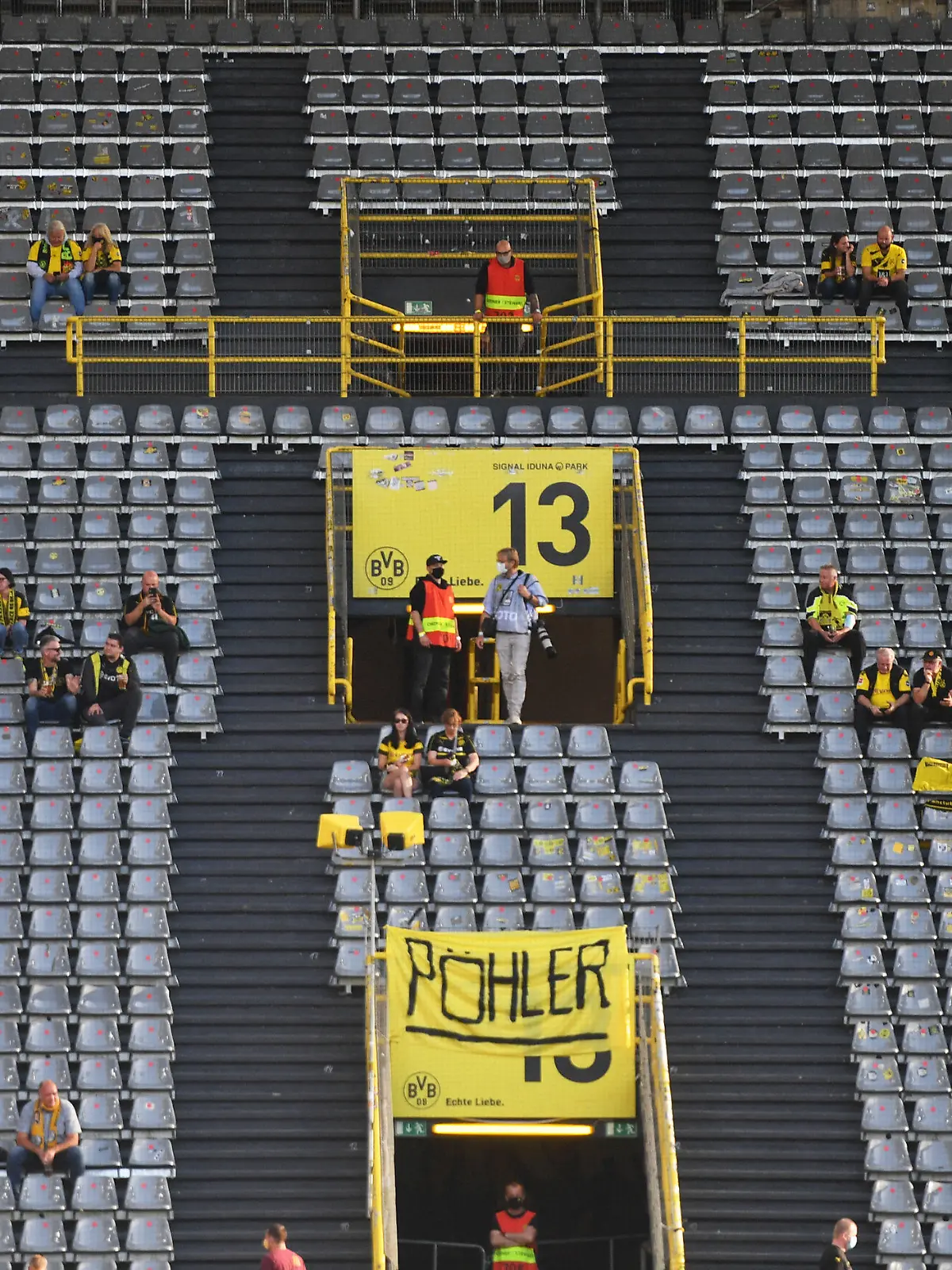 ARCHIV - 19.09.2020, Nordrhein-Westfalen, Dortmund: Fußball: Bundesliga, Borussia Dortmund - Borussia Mönchengladbach, 1. Spieltag im Signal Iduna Park. Zuschauer sitzen vor dem Spiel auf der Tribüne. WICHTIGER HINWEIS: Gemäß den Vorgaben der DFL Deutsche Fußball Liga bzw. des DFB Deutscher Fußball-Bund ist es untersagt, in dem Stadion und/oder vom Spiel angefertigte Fotoaufnahmen in Form von Sequenzbildern und/oder videoähnlichen Fotostrecken zu verwerten bzw. verwerten zu lassen. (Zu dpa "Offener BVB-Brief an die Fans: Profifußball kein Treiber der Pandemie") Foto: Bernd Thissen/dpa +++ dpa-Bildfunk +++