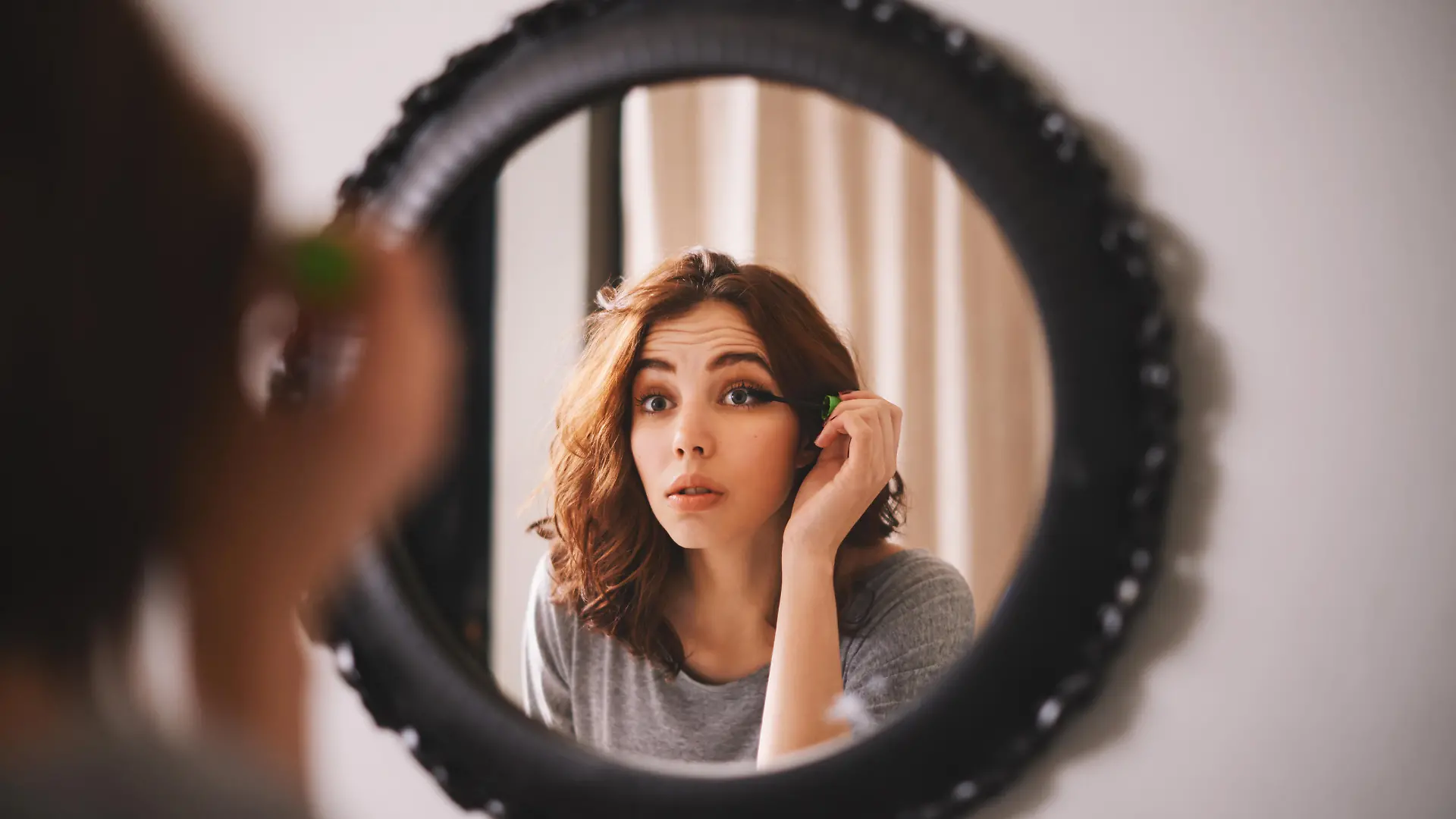 Cropped shot of a young woman putting on mascara