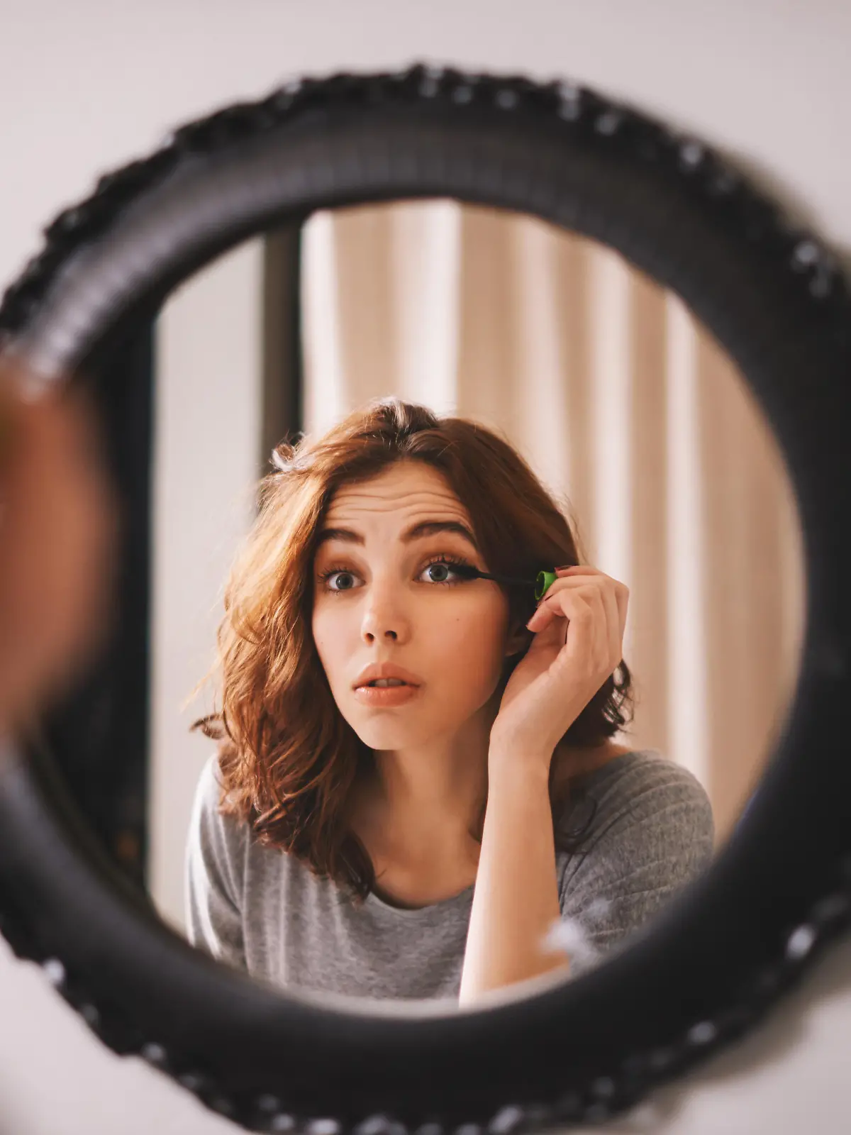 Cropped shot of a young woman putting on mascara