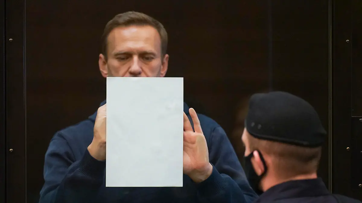 HANDOUT - 02.02.2021, Russland, Moskau: In diesem Handout-Foto, das vom Moskauer Stadtgericht zur Verfügung gestellt wurde, hält der russische Oppositionsführer Alexej Nawalny ein Dokument im Käfig stehend bei einer Anhörung zu einem Antrag des russischen Strafvollzugsdienstes, die Bewährungsstrafe von Nawalny aus der strafrechtlichen Verurteilung von 2014 in eine echte Gefängnisstrafe umzuwandeln. Foto: -/Moscow City Court/AP/dpa - ACHTUNG: Nur zur redaktionellen Verwendung und nur mit vollständiger Nennung des vorstehenden Credits +++ dpa-Bildfunk +++