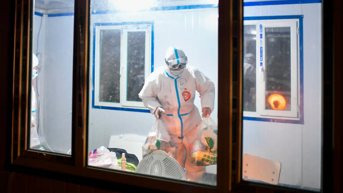 24.01.2021, China, Tonghua: Du Sicheng, ein Freiwilliger der Gemeinde Dongchang, überbringt Quarantänebewohnern Güter des täglichen Bedarfs an einem Kontrollpunkt einer Wohngemeinschaft in der Provinz Jilin im Nordosten der Volksrepublik China. Der 23-jährige Lehrer Du Sicheng, der in der Autonomen Region Tibet arbeitet, kehrte nach Beginn der Schulferien in seine Heimatstadt Tonghua zurück und schloss sich, nachdem seine Quarantäne am 23.01.2021 endete, den mehr als tausend Freiwilligen der Gemeinde an, um Menschen, die sich noch in Quarantäne befinden, mit Gütern des täglichen Bedarfs zu versorgen. Foto: Xu Chang/XinHua/dpa +++ dpa-Bildfunk +++