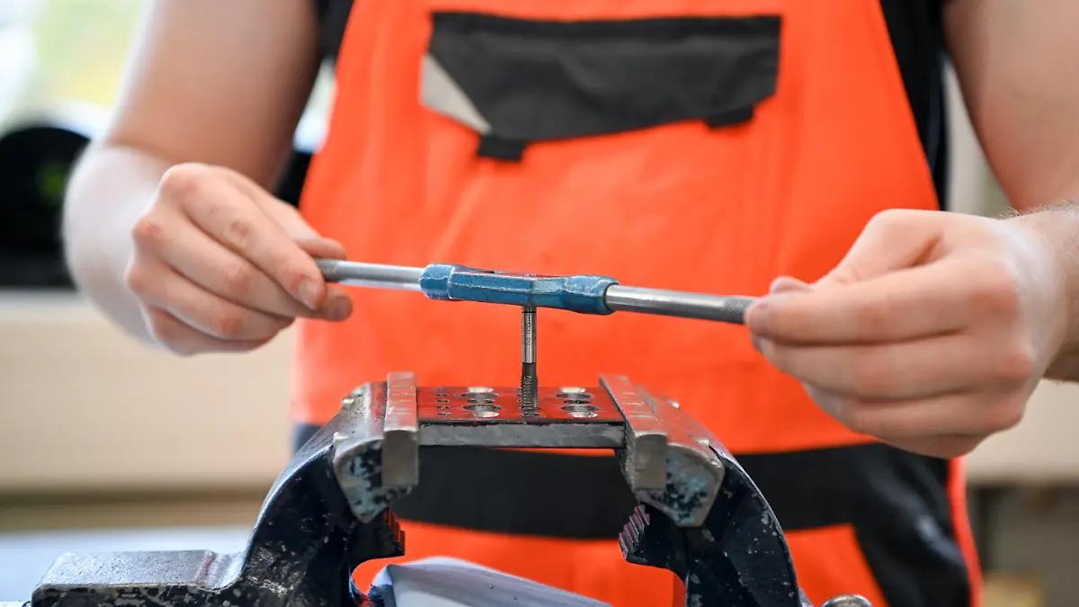 ARCHIV - 01.11.2021, Brandenburg, Potsdam: In einer Lehrwerkstatt bohrt ein Auszubildender im 1. Lehrjahr im Rahmen seiner Ausbildung ein Gewinde. Über die Entwicklung der beruflichen Ausbildung in Deutschland berichtet an diesem Mittwoch das Statistische Bundesamt. (zu dpa "Statistik zu Ausbildungsverträgen erwartet") Foto: Jens Kalaene/dpa-Zentralbild/dpa +++ dpa-Bildfunk +++
