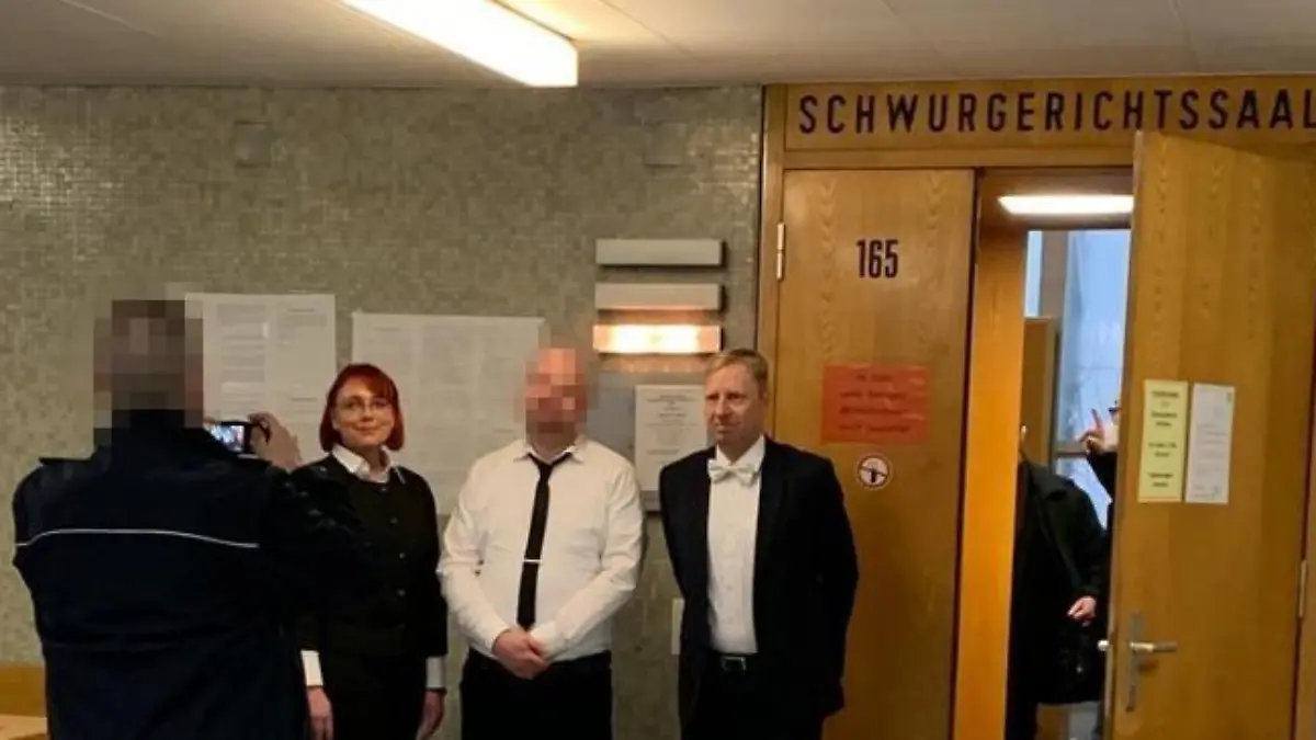 Markus H. macht direkt nach dem Urteil im Lübcke-Prozess Fotos mit seinen beiden Verteidigern - fotografiert von einem Justizbeamten.