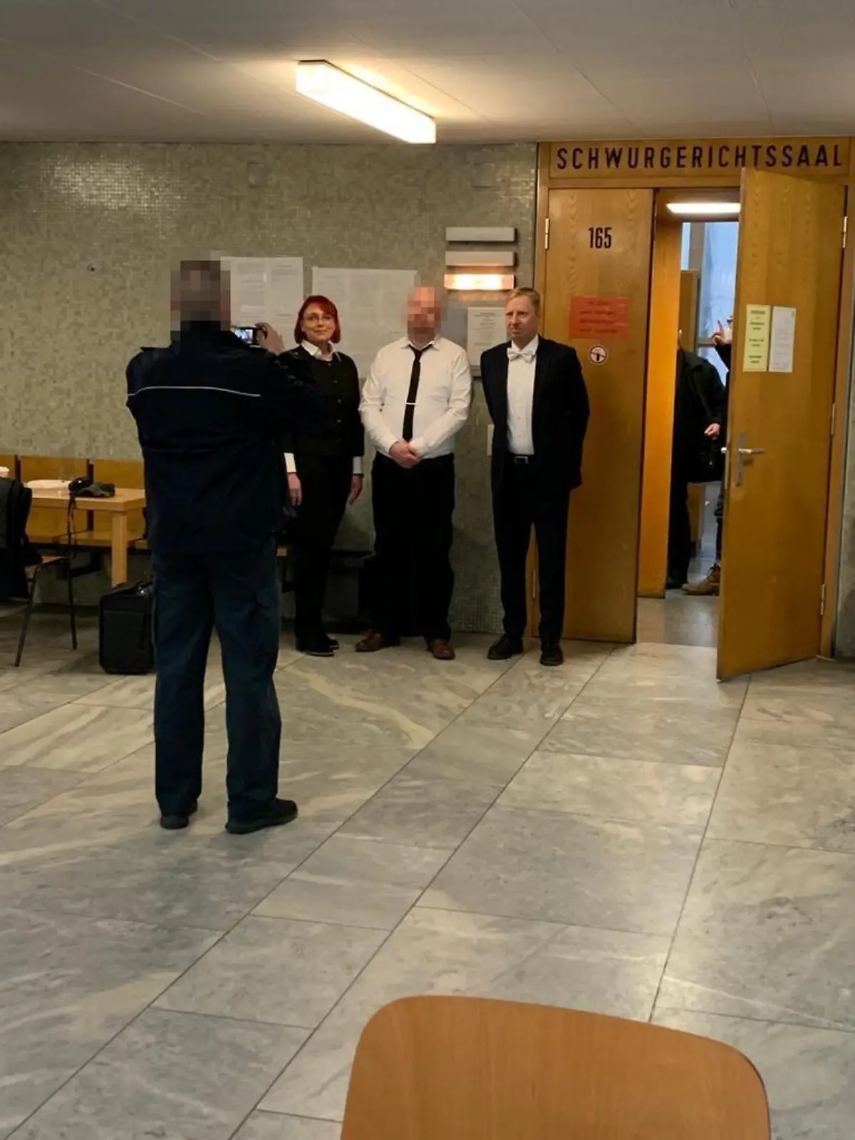 Markus H. macht direkt nach dem Urteil im Lübcke-Prozess Fotos mit seinen beiden Verteidigern - fotografiert von einem Justizbeamten.