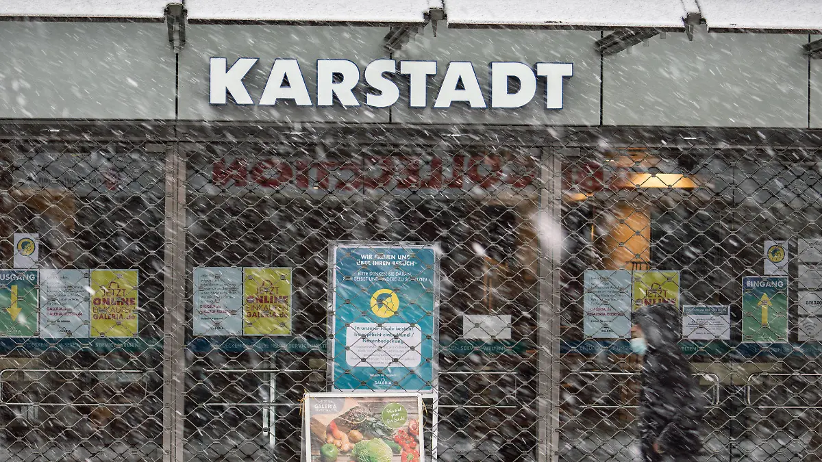 27.01.2021, Hessen, Bad Homburg: Ein Mann geht bei leichtem Schneetreiben am geschlossenen Haupteingang der Bad Homburger Karstadt-Filiale vorbei. Die Bundesregierung verhandelt mit dem angeschlagenen Warenhauskonzern Galeria Karstadt Kaufhof über Staatshilfen. Eine Entscheidung könnte am Mittwoch (27.01.2021) in einer Sitzung des Ausschusses des Wirtschaftsstabilisierungsfonds fallen. Foto: Frank Rumpenhorst/dpa +++ dpa-Bildfunk +++
