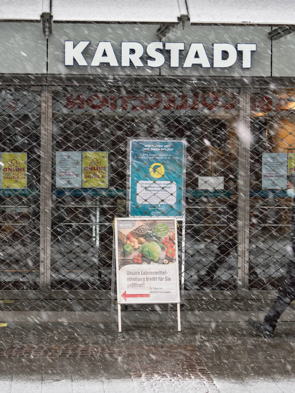 27.01.2021, Hessen, Bad Homburg: Ein Mann geht bei leichtem Schneetreiben am geschlossenen Haupteingang der Bad Homburger Karstadt-Filiale vorbei. Die Bundesregierung verhandelt mit dem angeschlagenen Warenhauskonzern Galeria Karstadt Kaufhof über Staatshilfen. Eine Entscheidung könnte am Mittwoch (27.01.2021) in einer Sitzung des Ausschusses des Wirtschaftsstabilisierungsfonds fallen. Foto: Frank Rumpenhorst/dpa +++ dpa-Bildfunk +++