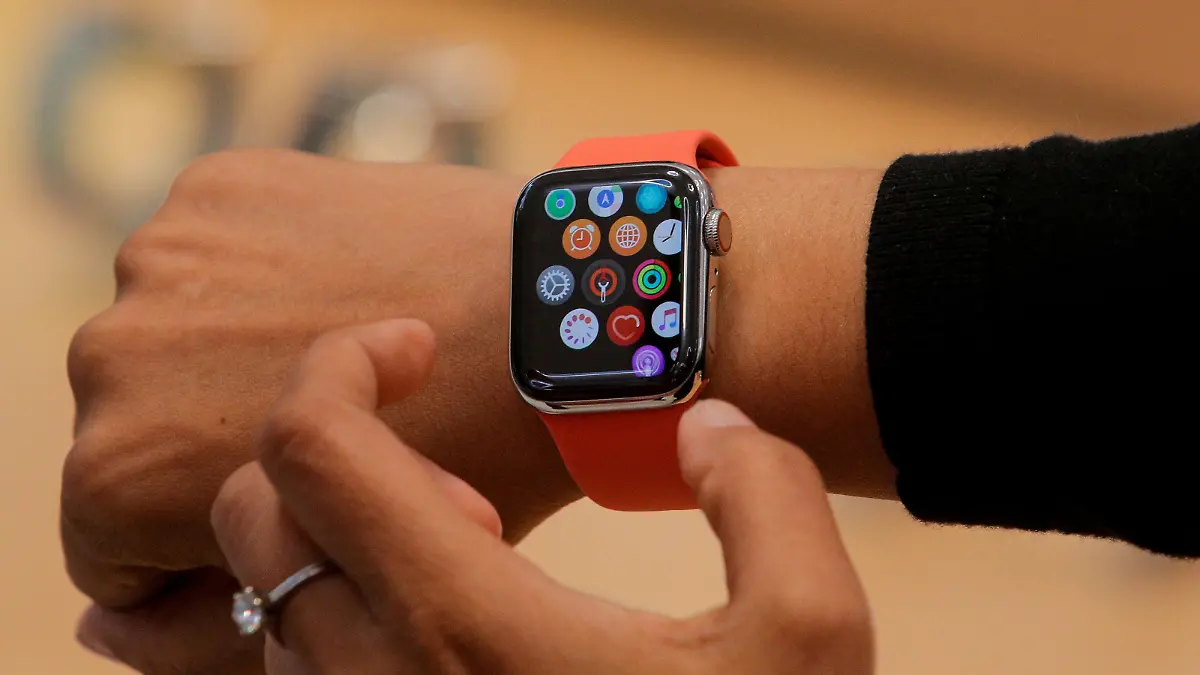 FILE PHOTO: An Apple Store employee shows the new Series 5 Apple Watch during the preview of the redesigned and reimagined Apple Fifth Avenue store in New York, U.S., September 19, 2019. REUTERS/Brendan McDermid/File Photo/File Photo