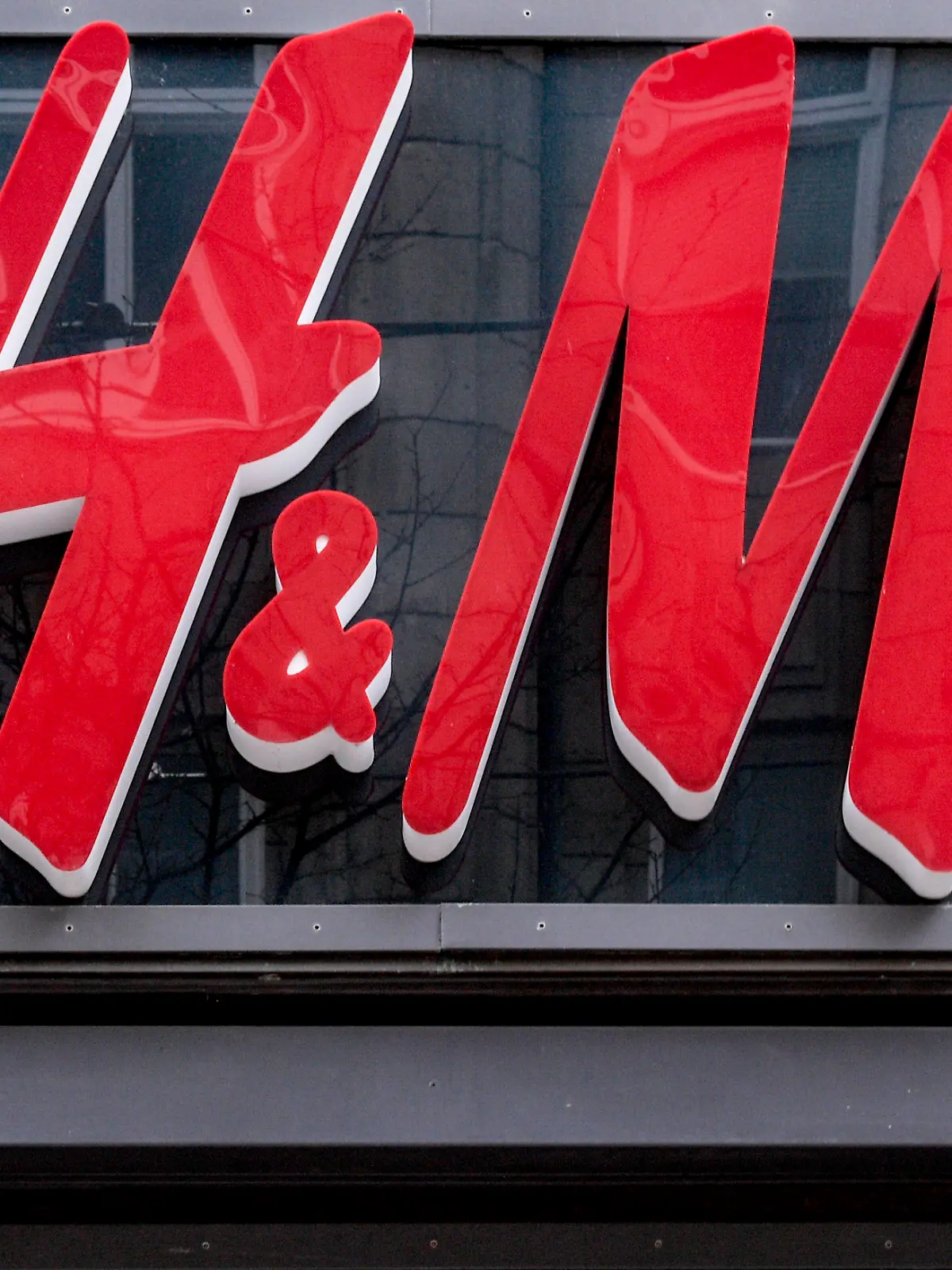 ARCHIV - 01.04.2020, Hamburg: Das Logo der Modekette H&M hängt über dem Eingang des Kaufhausesin der Innenstadt von Hamburg entlang. Der Moderiese H&M hat im Corona-Jahr 2020 weniger Kleidung an den Kunden gebracht als im Vorjahr. (zu dpa «Jahresumsatz von H&M-Gruppe fällt coronabedingt deutlich») Foto: Axel Heimken/dpa +++ dpa-Bildfunk +++
