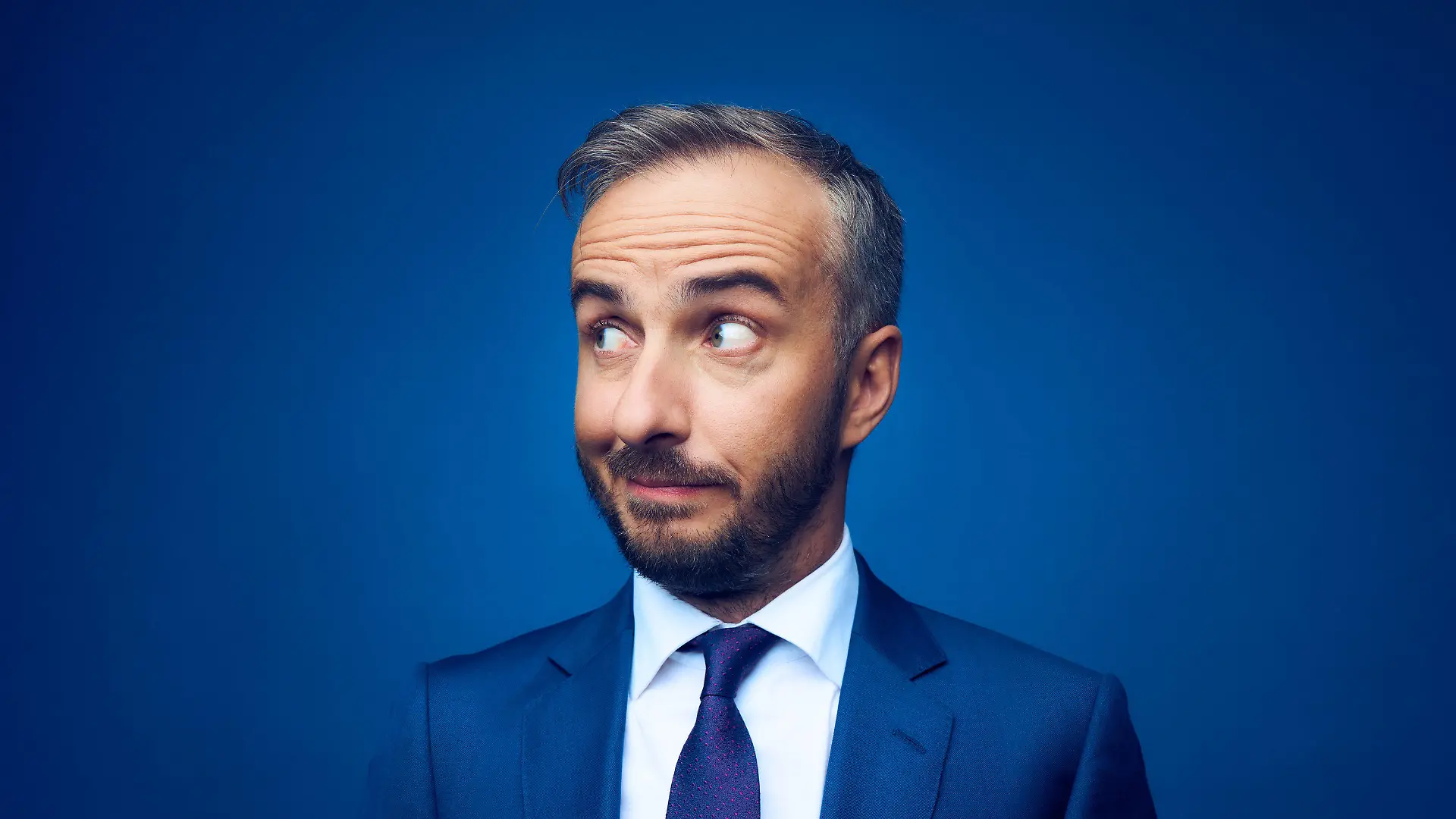 HANDOUT - 03.11.2020, ---: Jan Böhmermann im blauen Anzug vor blauem Hintergrund (undatierte Aufnahme). Böhmermanns neue ZDF-Satiresendung «ZDF Magazin Royale» wird ab dem 6.11.20 im ZDF ausgestrahlt. Foto: Jens Koch/ZDF/dpa - ACHTUNG: Nur zur redaktionellen Verwendung im Zusammenhang mit einer Berichterstattung über die Sendung und nur mit vollständiger Nennung des vorstehenden Credits. Keine Verwendung nach dem 20.09.2022. +++ dpa-Bildfunk +++