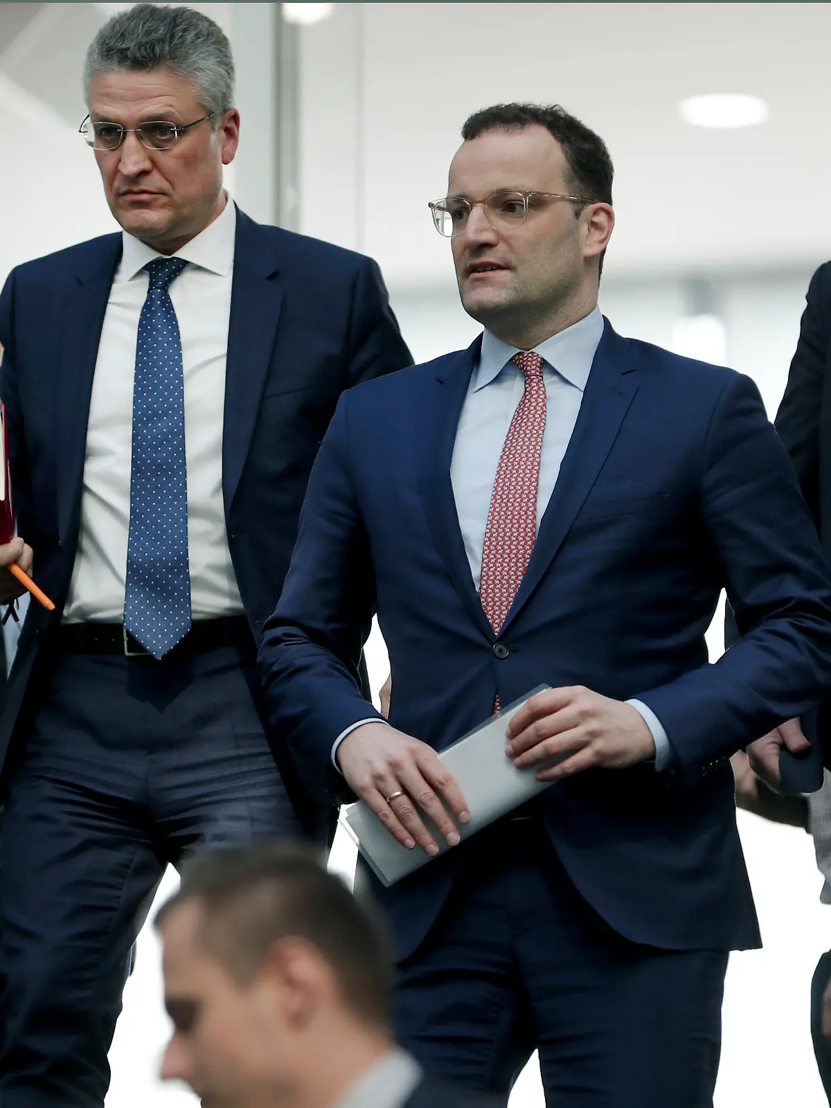 File - In this Thursday, March 26, 2020 file photo, Lothar H. Wieler, president of the Robert-Koch-Institute, top left, and German Health Minister Jens Spahn of the Christian Democratic Union, CDU, party, top center, leave after a press conference in Berlin, Germany, on the fight against the new coronavirus outbreak. German Chancellor Angela Merkel's center-right party, the Christian Democratic Union, CDU, is choosing a new leader on the weekend Saturday Jan. 16 and Sunday Jan. 17, 2021, a decision that will help determine who succeeds Merkel at the helm of the European Union's biggest economy after a 16-year reign.  (AP Photo/Michael Sohn, file)