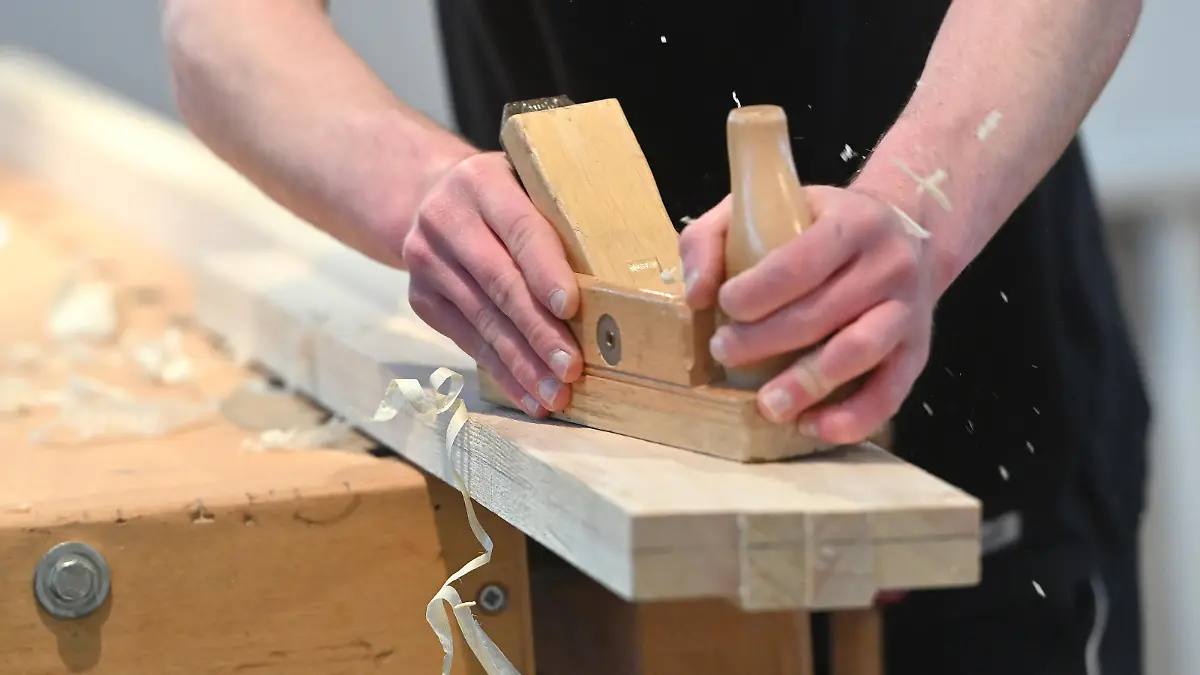 Azubi, Ausbildung zum Schreiner,Schreinerhandwerk, Hobel,Holz,Spaene,Hobelspaene. Auszubildender,Lehrling,Ausbildung,Lehrberuf. Internationale Handwerksmesse IHM Muenchen steht unter dem Motto Zukunft Handwerk am 08.03.2023. ?