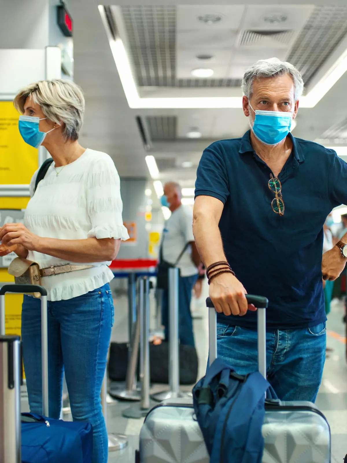 Mann und Frau mit Corona-Masken am Flughafen