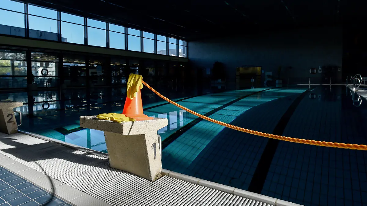 05.11.2020, Berlin: Leeres Becken im Stadtbad Lankwitz. Auf einem Startblock steht ein Warnkegel, auf welchen Gummihandschuhe liegen. Die Schwimmbäder sind für den November aufgrund des Lockdowns geschlossen. Foto: Kira Hofmann/dpa-Zentralbild/dpa +++ dpa-Bildfunk +++