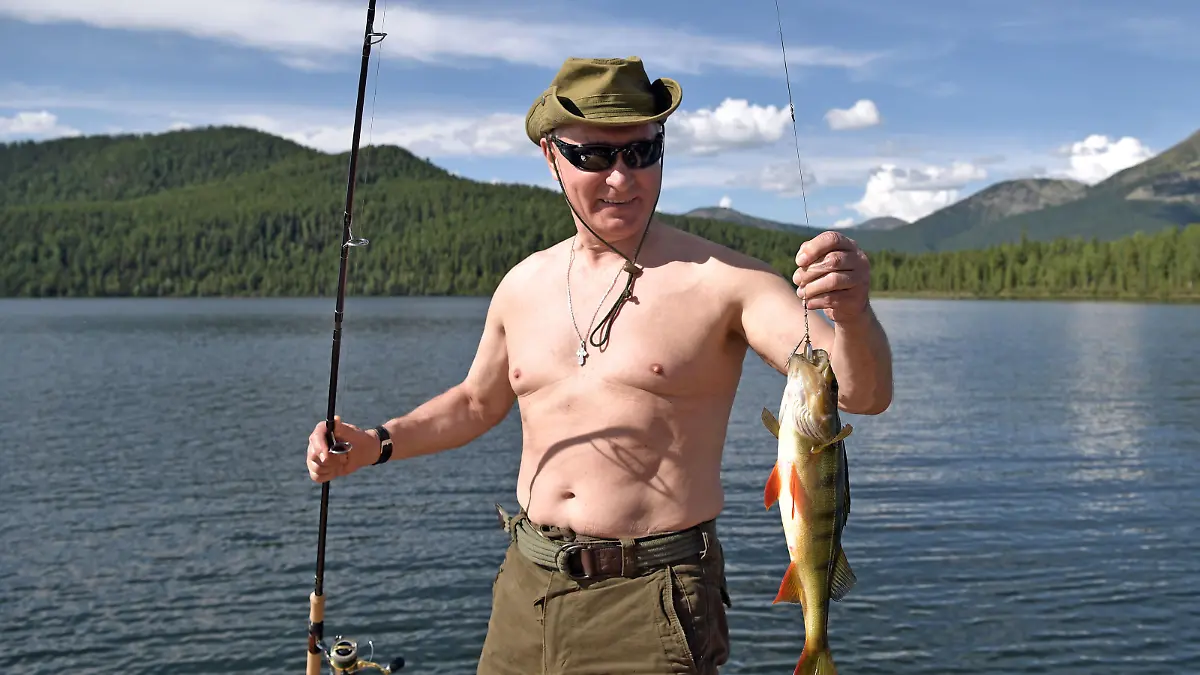 In this photo released by Kremlin press service on Saturday, Aug. 5, 2017, Russian President Vladimir Putin holds a fish he caught during a mini-break in the Siberian Tyva region, a few days ago. (Alexei Nikolsky, Sputnik, Kremlin Pool Photo via AP)