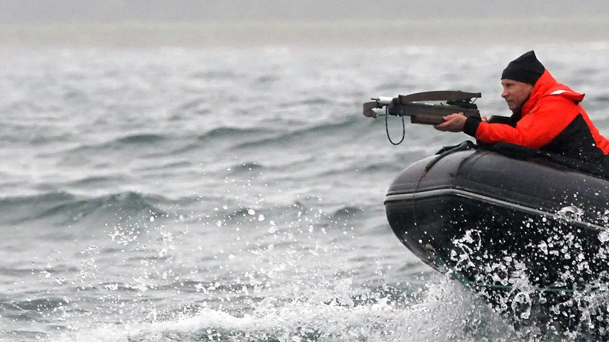 Russian Prime Minister Vladimir Putin aims a crossbow as he sails aboard a rubber motorboat during a scientific expedition to study grey whales in Olga Bay in the Kronotsky Nature preserve in Kamchatka, Russia 25 August 2010. Vladimir Putin was invited to joint the procedure of taking whales' skin samples for identification the population the whales belong to. EPA/ALEXEY DRUZHINYN RIA NOVOSTI /*** NO SALES NO ARCHIVES NOT FOR USE AFTER 25 SEPTEMBER 2010*** ++