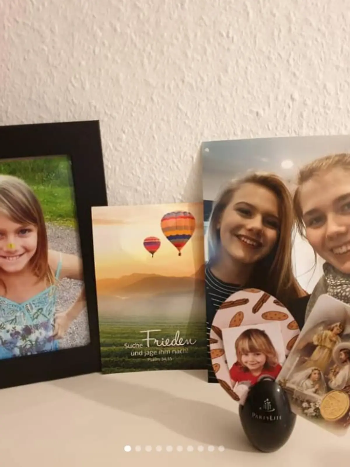 Ein Kreuz und ein schwarz eingerahmtes Bild von Rebecca Reusch.