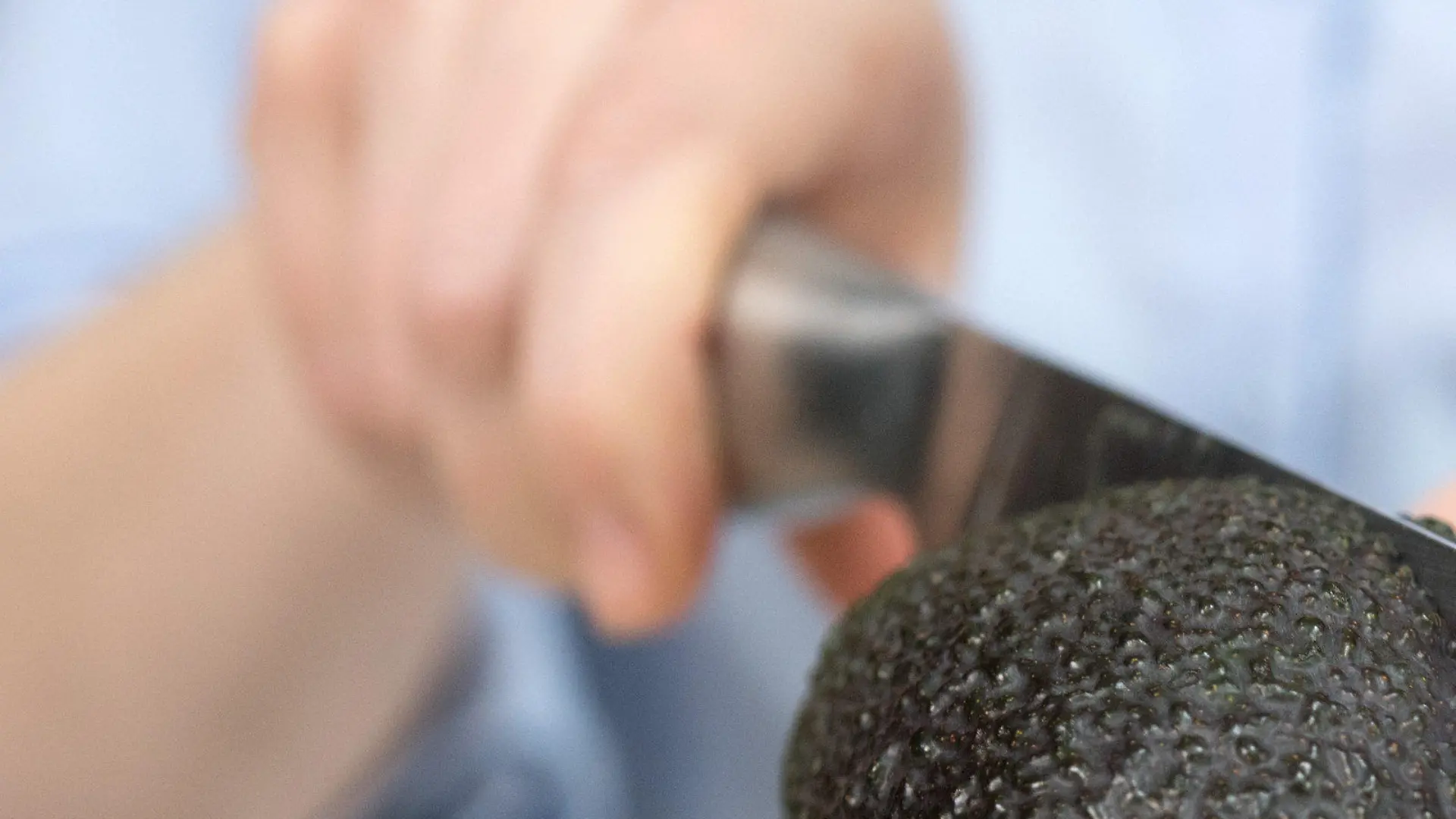 ARCHIV - Eine Frau schneidet am 15.02.2017 in Berlin mit einem Messer eine Avocado. (Zu doa «Mediziner warnt vor "Avocado-Hand"» vom 11.05.2017) Foto: Andrea Warnecke/dpa +++(c) dpa - Bildfunk+++