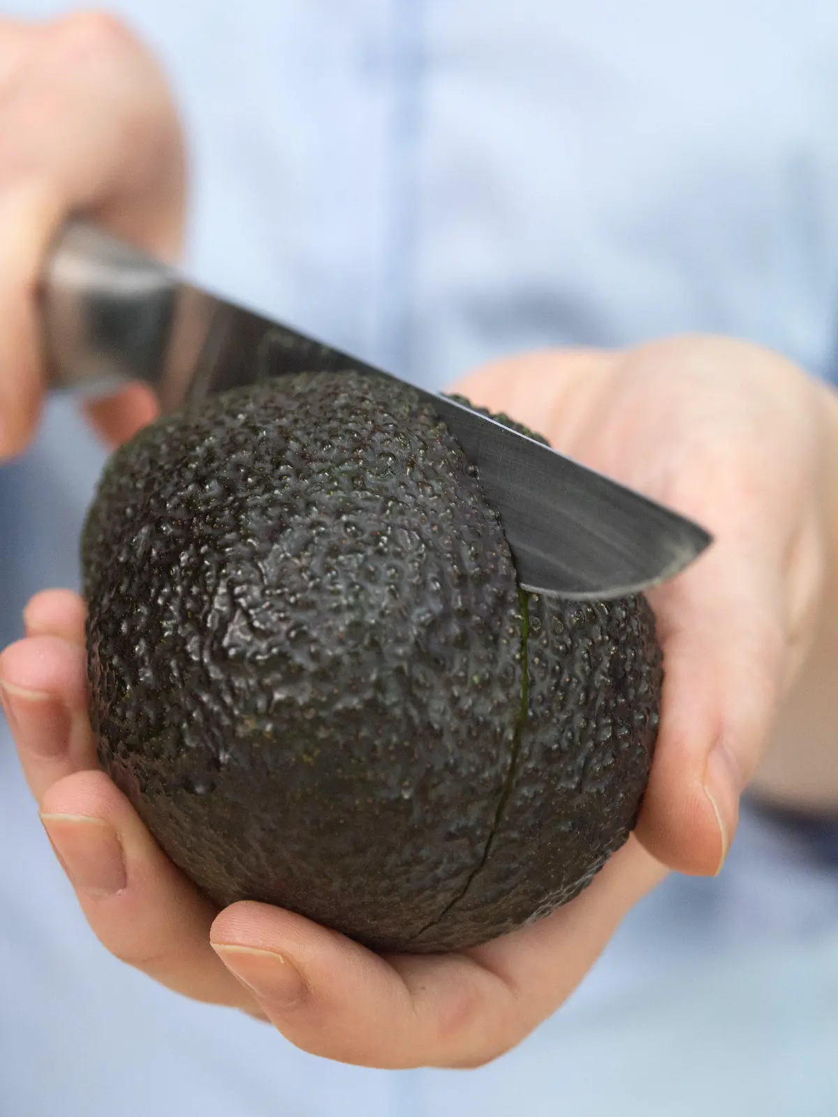 ARCHIV - Eine Frau schneidet am 15.02.2017 in Berlin mit einem Messer eine Avocado. (Zu doa «Mediziner warnt vor "Avocado-Hand"» vom 11.05.2017) Foto: Andrea Warnecke/dpa +++(c) dpa - Bildfunk+++