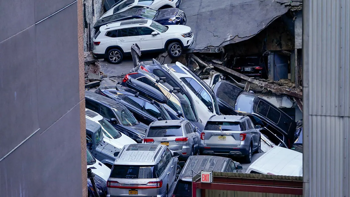 dpatopbilder - 18.04.2023, USA, New York: An der Stelle, an der ein Parkhaus im Financial District von New York teilweise eingestürzt ist, stapeln sich Autos übereinander. Zahlreiche Autos wurden zusammengedrückt. Die Rettungsarbeiten mussten zeitweise unterbrochen werden, weil das größtenteils in sich zusammengesackte Parkhaus an der Südspitze Manhattans noch weiter einzustürzen drohte. Foto: Mary Altaffer/AP/dpa +++ dpa-Bildfunk +++