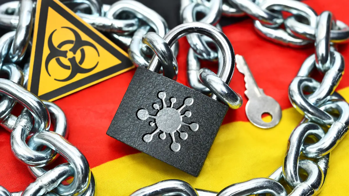 FOTOMONTAGE, Geschlossenes Vorhängeschloss mit Coronavirus-Zeichen auf Deutschlandfahne, Symbolfoto Lockdown *** PHOTOMONTAGE, Closed padlock with Coronavirus sign on German flag, Symbol photo lockdown