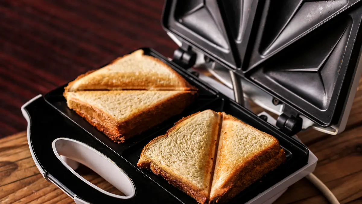 Preparing two grilled cheese sandwiches in a sandwich iron