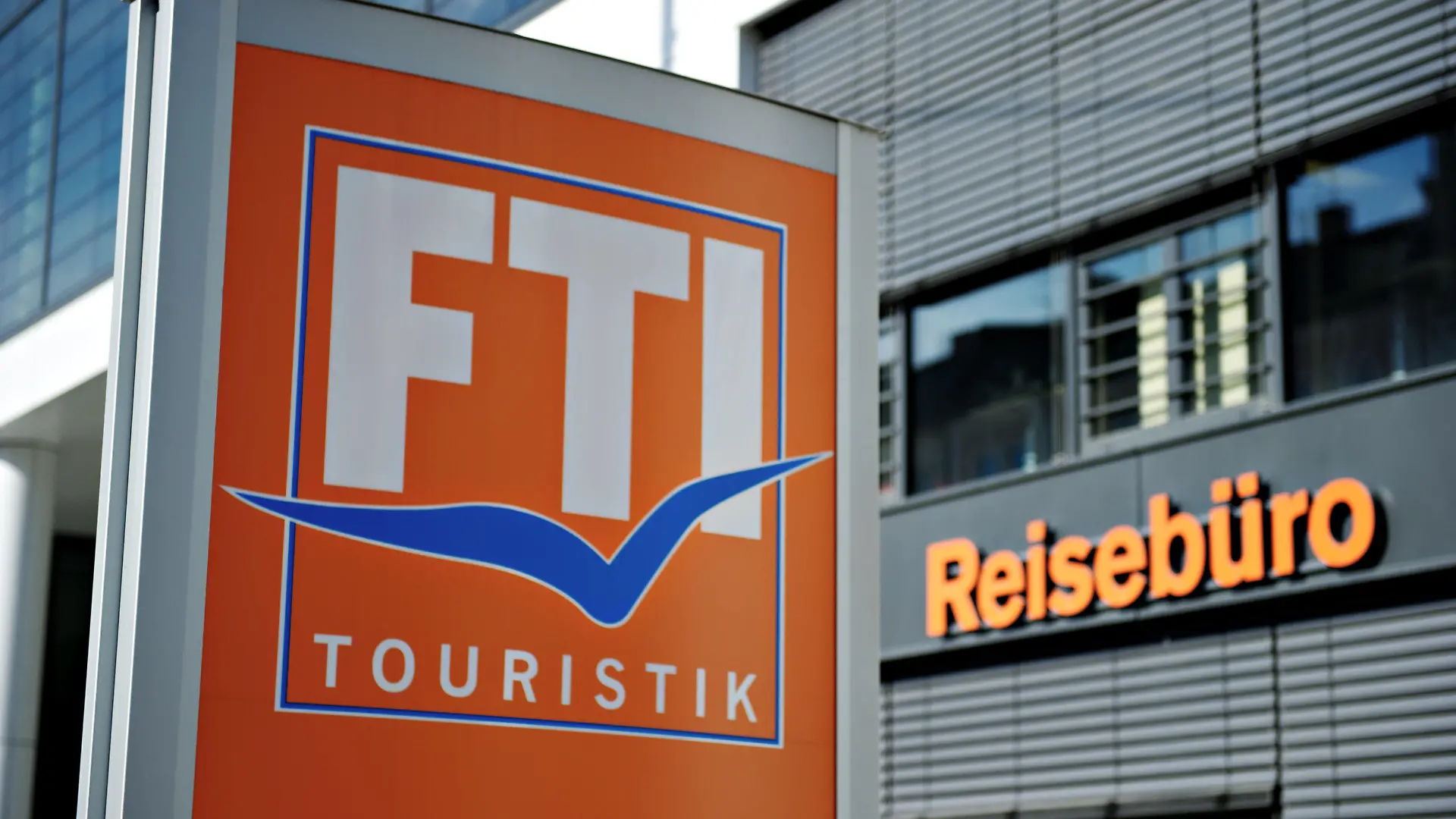 ARCHIV - 03.03.2014, Bayern, München: Das Logo des Reiseveranstalters FTI-Touristik steht vor einem Reisebüro. Europas drittgrößer Reiseveranstalter FTI steckt durch die Corona-Krise in Geldnot, bekommt jetzt Staatshilfe und gibt einen großen Teil seiner Geschäfte auf. Foto: Rene Ruprecht/dpa +++ dpa-Bildfunk +++
