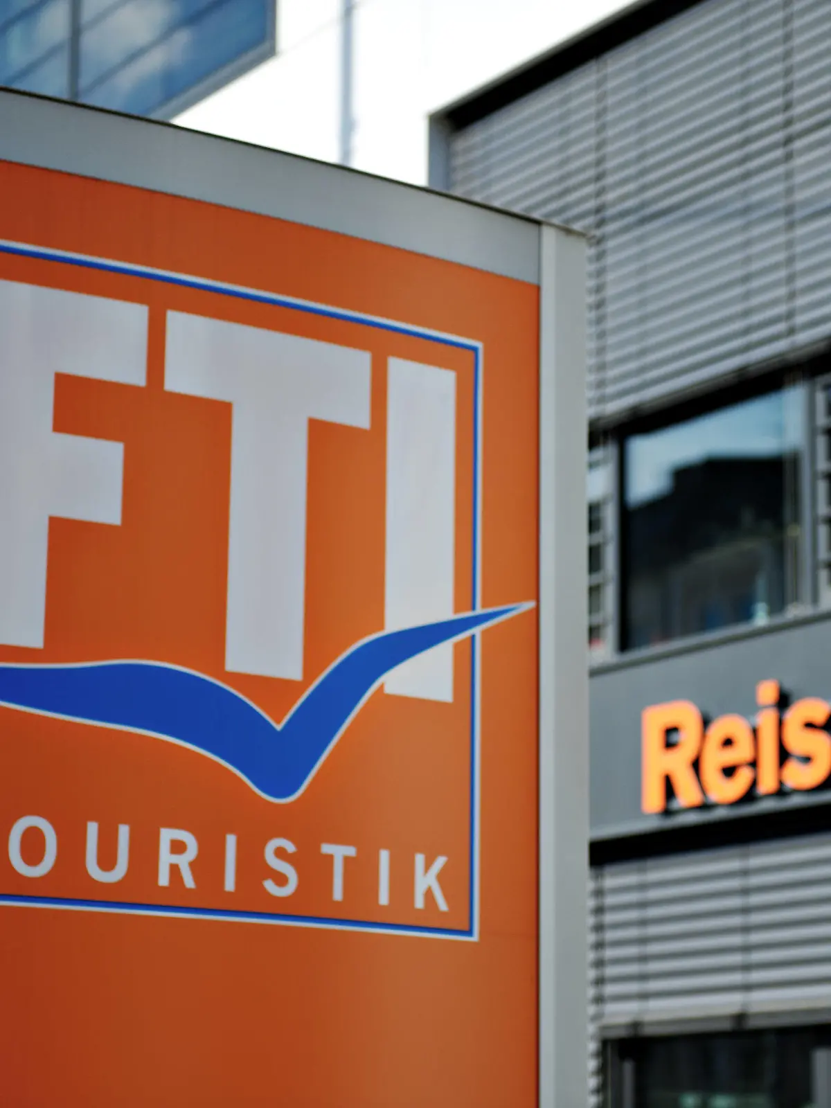ARCHIV - 03.03.2014, Bayern, München: Das Logo des Reiseveranstalters FTI-Touristik steht vor einem Reisebüro. Europas drittgrößer Reiseveranstalter FTI steckt durch die Corona-Krise in Geldnot, bekommt jetzt Staatshilfe und gibt einen großen Teil seiner Geschäfte auf. Foto: Rene Ruprecht/dpa +++ dpa-Bildfunk +++
