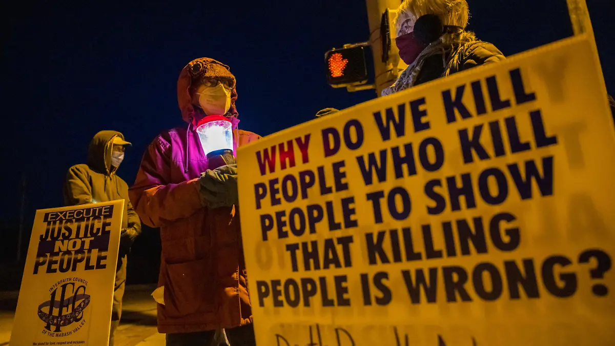 12.01.2021, USA, Bloomington: Glenda Breeden (M) aus Bloomington, Aktivistin gegen die Todesstrafe, hält eine Lampe, bei einem Protest gegen die Hinrichtung von Lisa Montgomery und zwei weiteren Personen im Gefängnis in Terre Haute im US-Bundesstaat Indiana. Die Regierung des abgewählten US-Präsidenten Trump hat eine wegen Mordes verurteilte Frau hinrichten lassen. Die 52-jährige Lisa Montgomery starb in der Nacht zum Mittwoch (Ortszeit) durch eine Giftspritze im Gefängnis in Terre Haute. Foto: Jeremy Hogan/SOPA Images via ZUMA Wire/dpa +++ dpa-Bildfunk +++